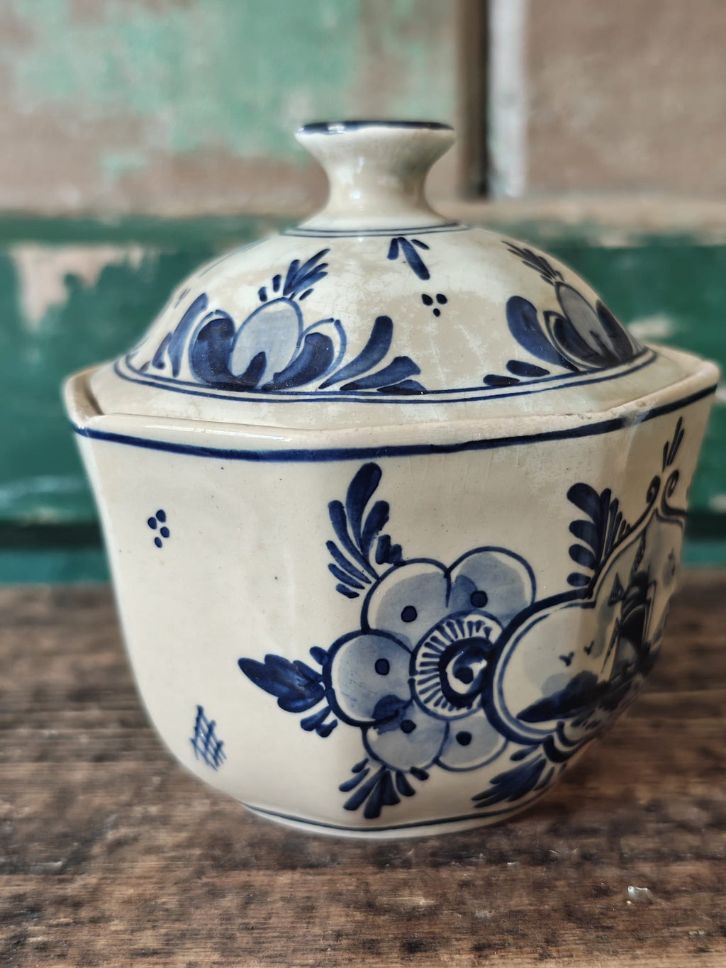 A vintage blue and white hand-painted stoneware lidded sugar bowl.