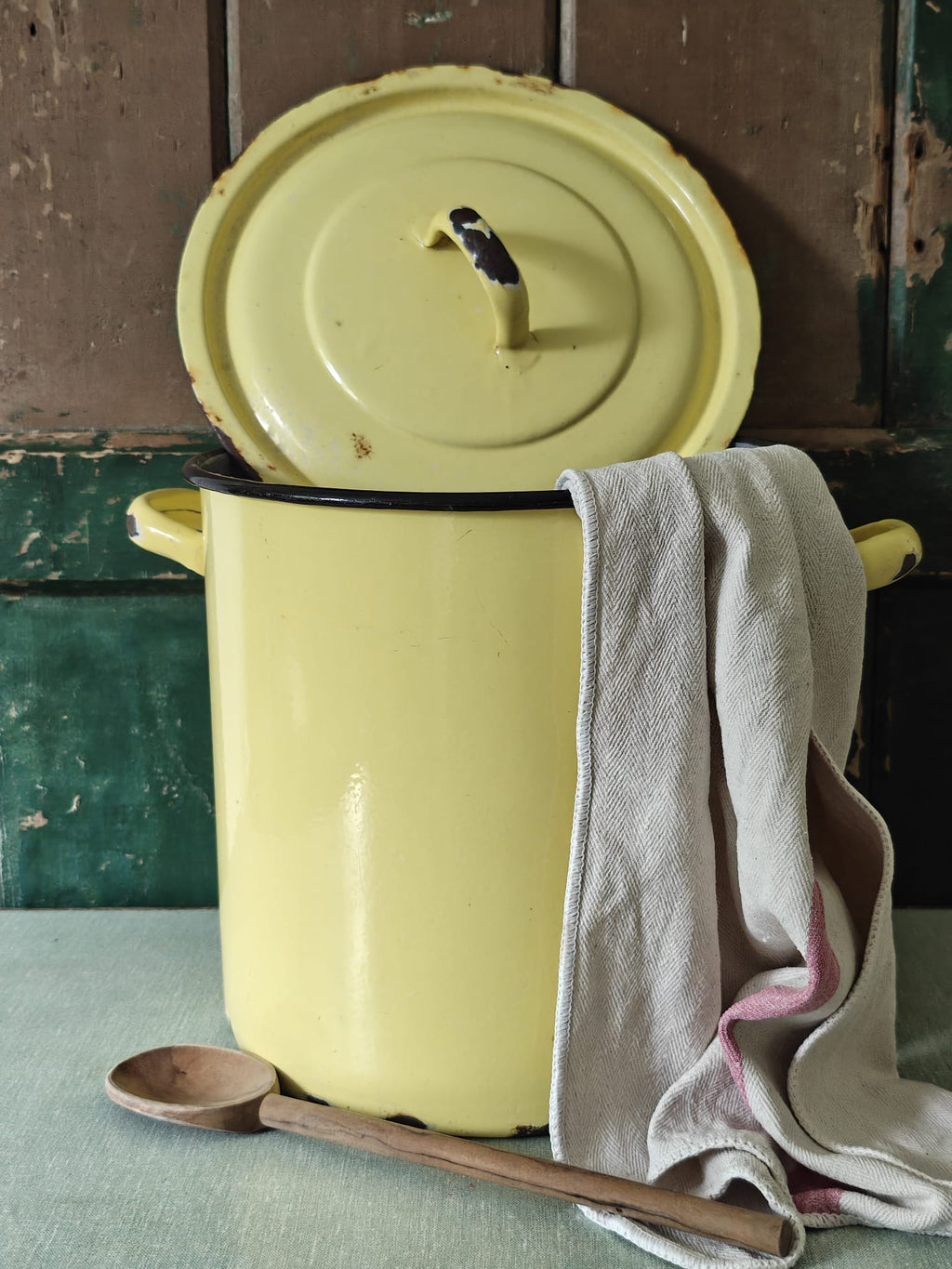 Yellow enameled pot with a lid.