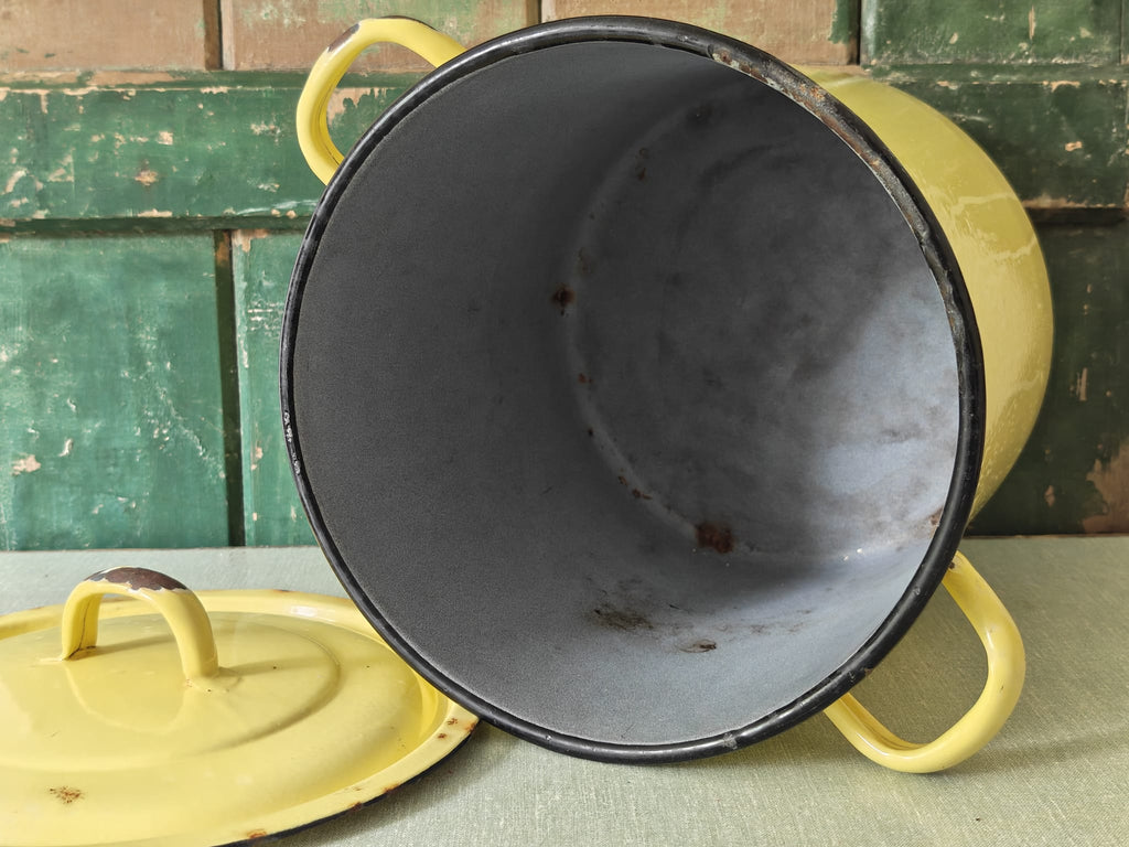 Yellow enameled pot with blue interior.