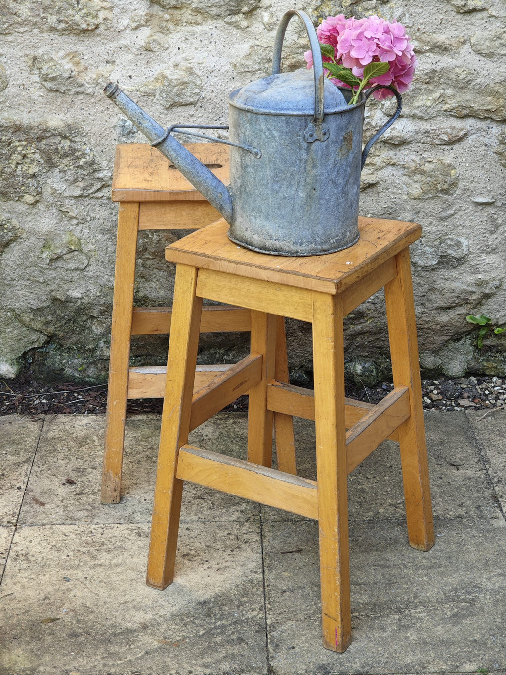 A vintage wooden lab stool and another behind it