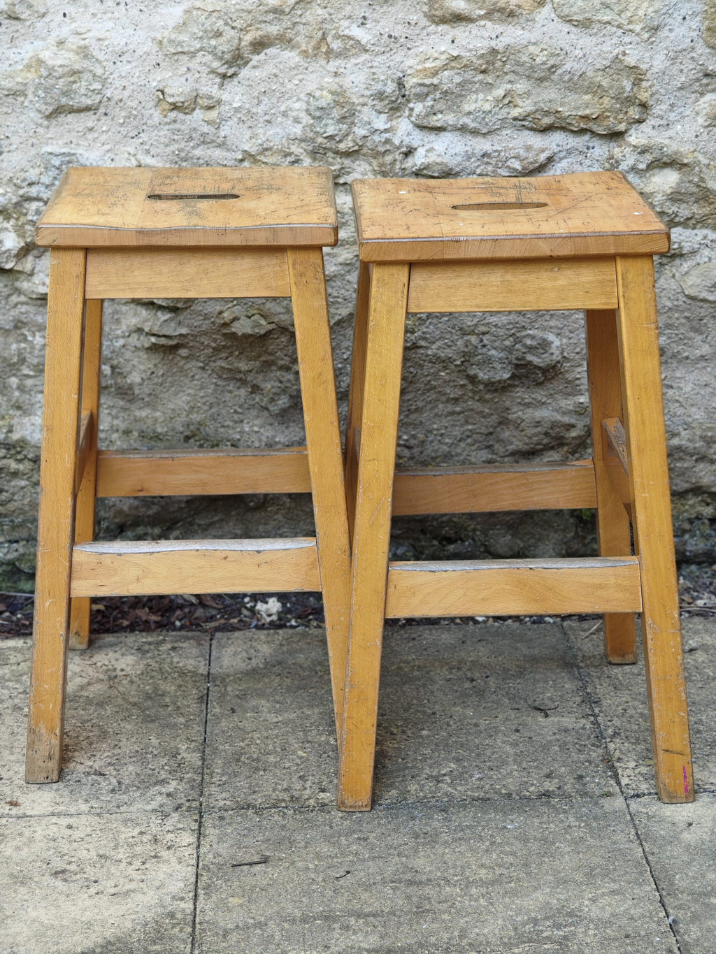 Two light beech wood stools with square seats.