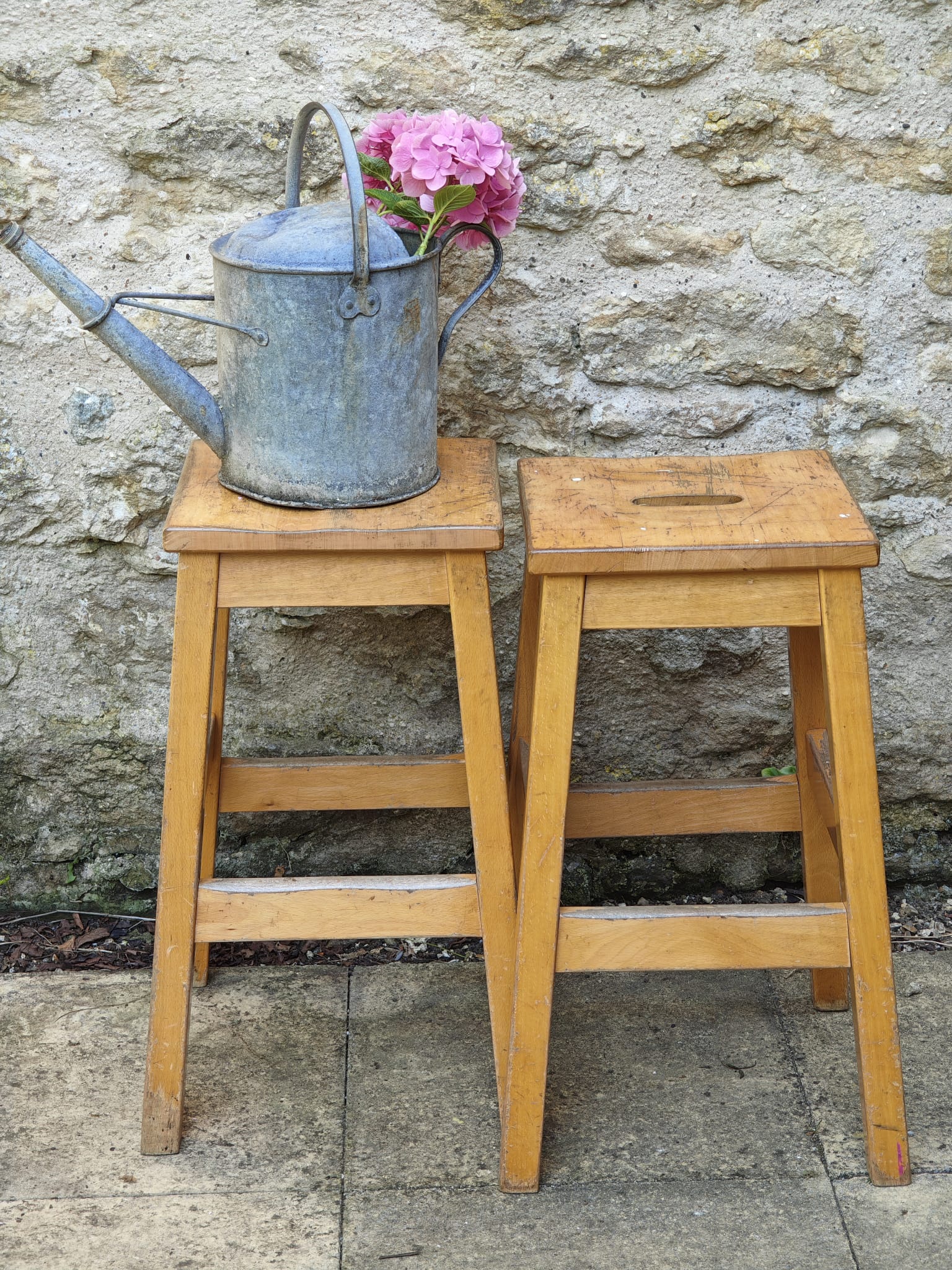 Two light wood stools with cutout handles