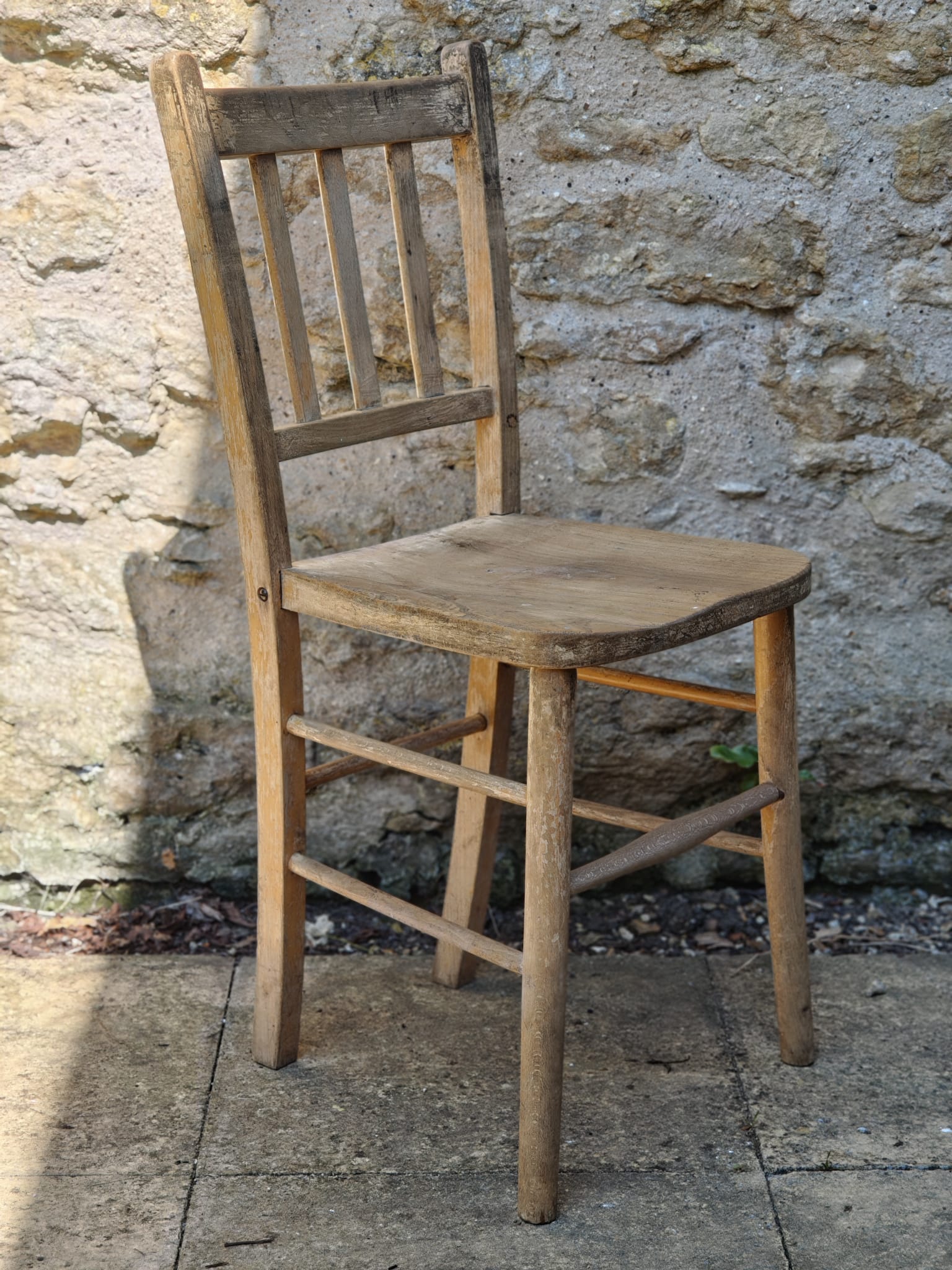 A rustic wooden chair with a slatted backrest.