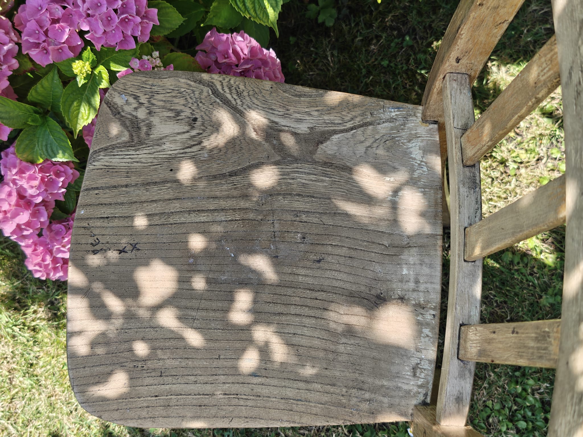 A rustic wooden chair seat viewed from above