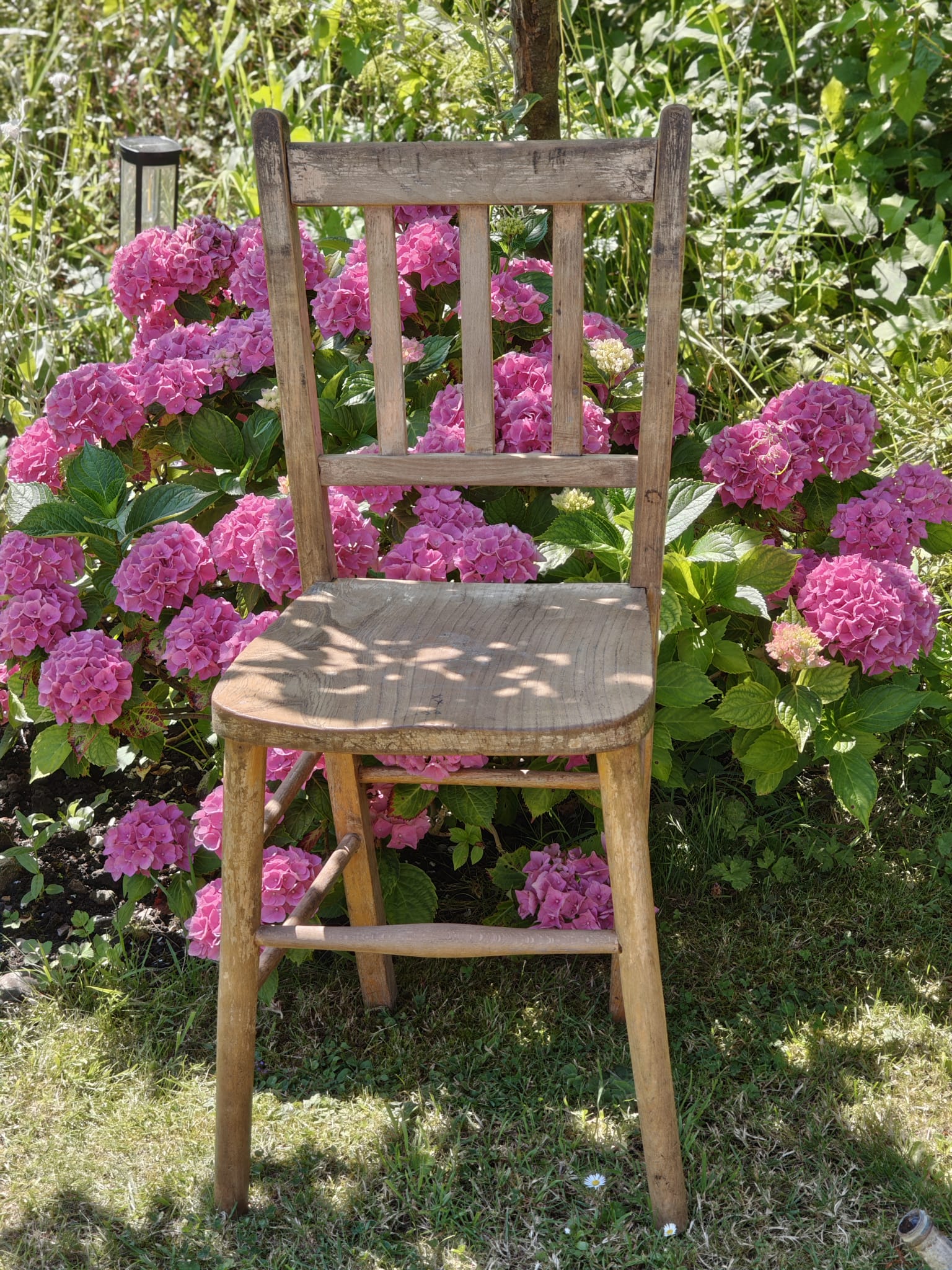 A rustic wooden chair with a slatted back.