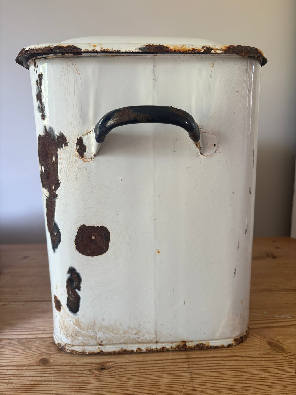A vintage white enamel storage canister.