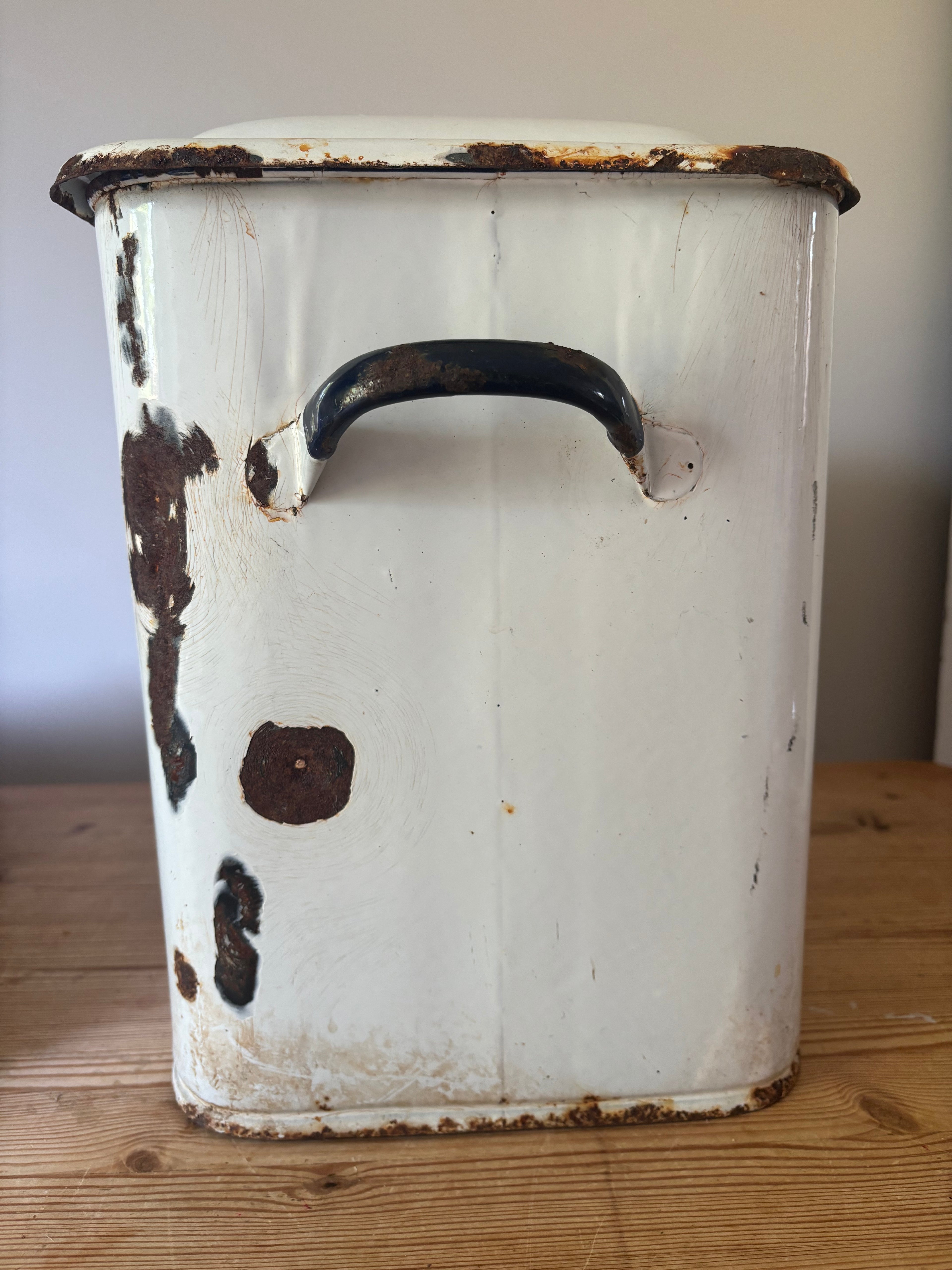 A vintage white enamel storage canister.