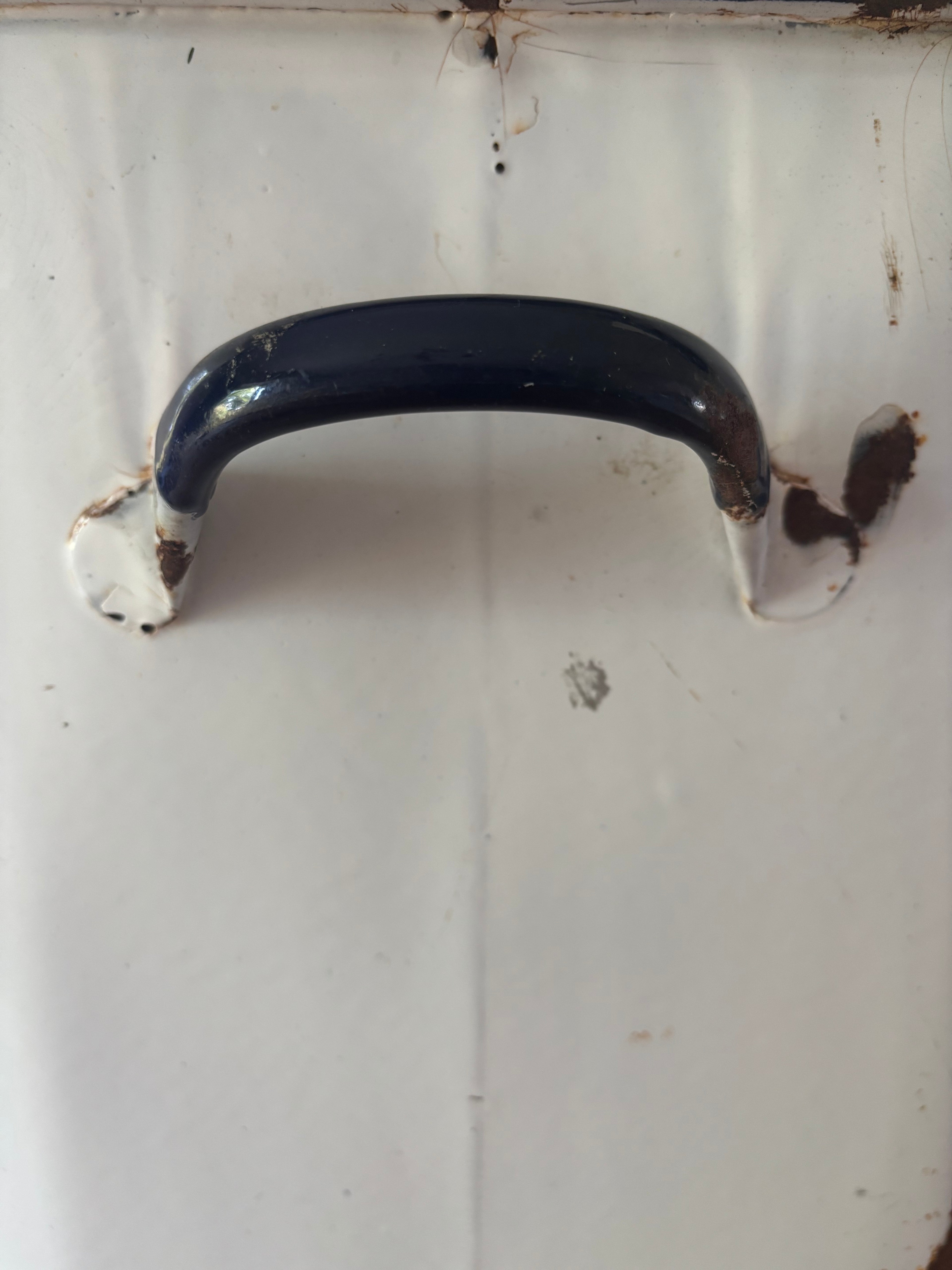 A close-up of a vintage-style dark blue enamel handle.