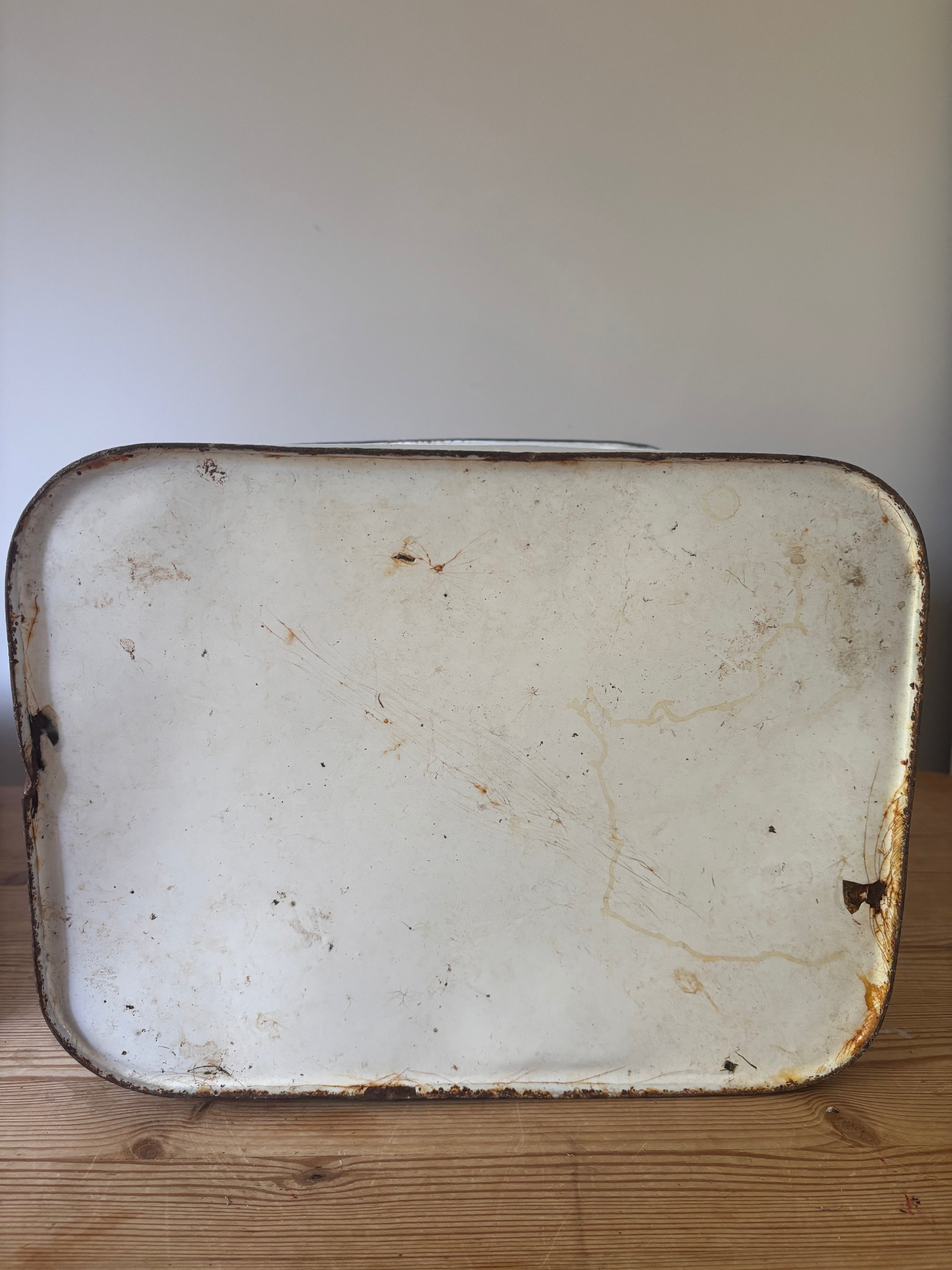 The underneath of a vintage emamel bread bin.