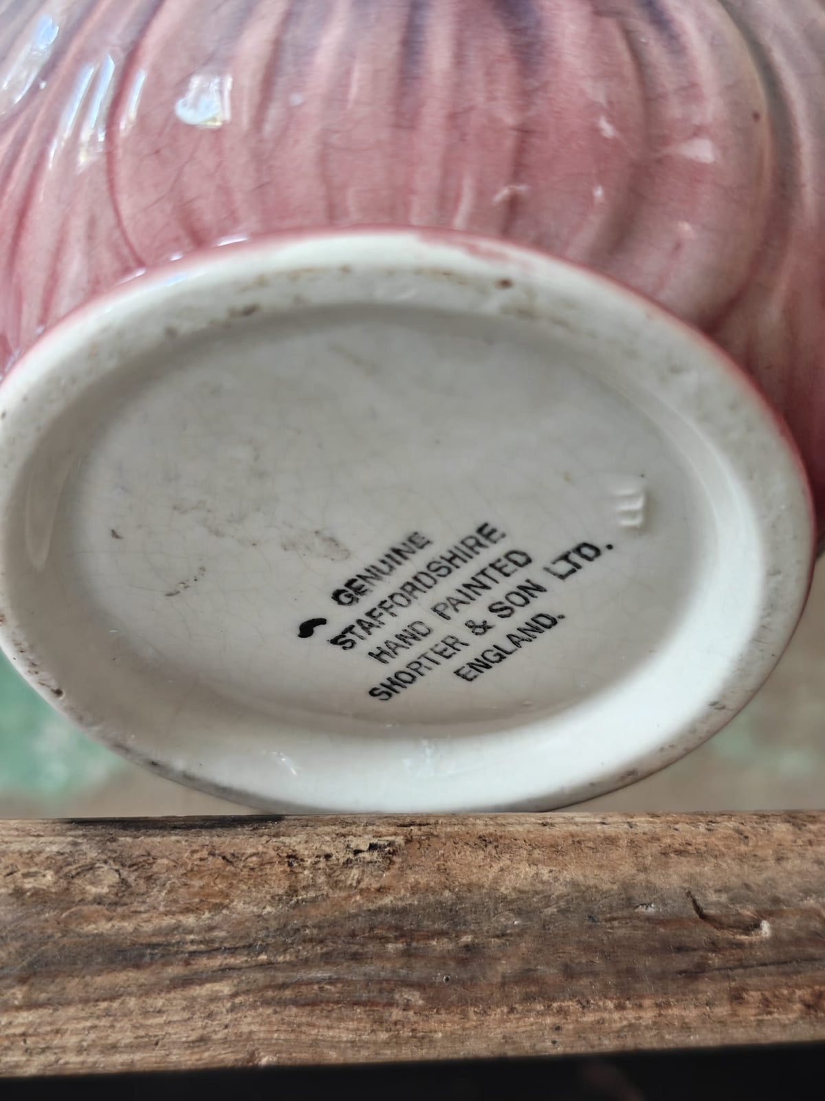 Close-up of the bottom of a hand-painted Staffordshire pottery vessel, showing the printed text 'GENUINE STAFFORDSHIRE HAND PAINTED SHORTEL & SON LTD. ENGLAND'.