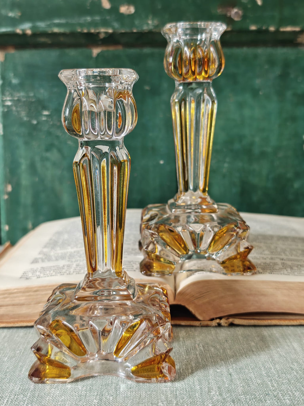 Two clear glass candlestick holders with fluted stems and faceted bases.
