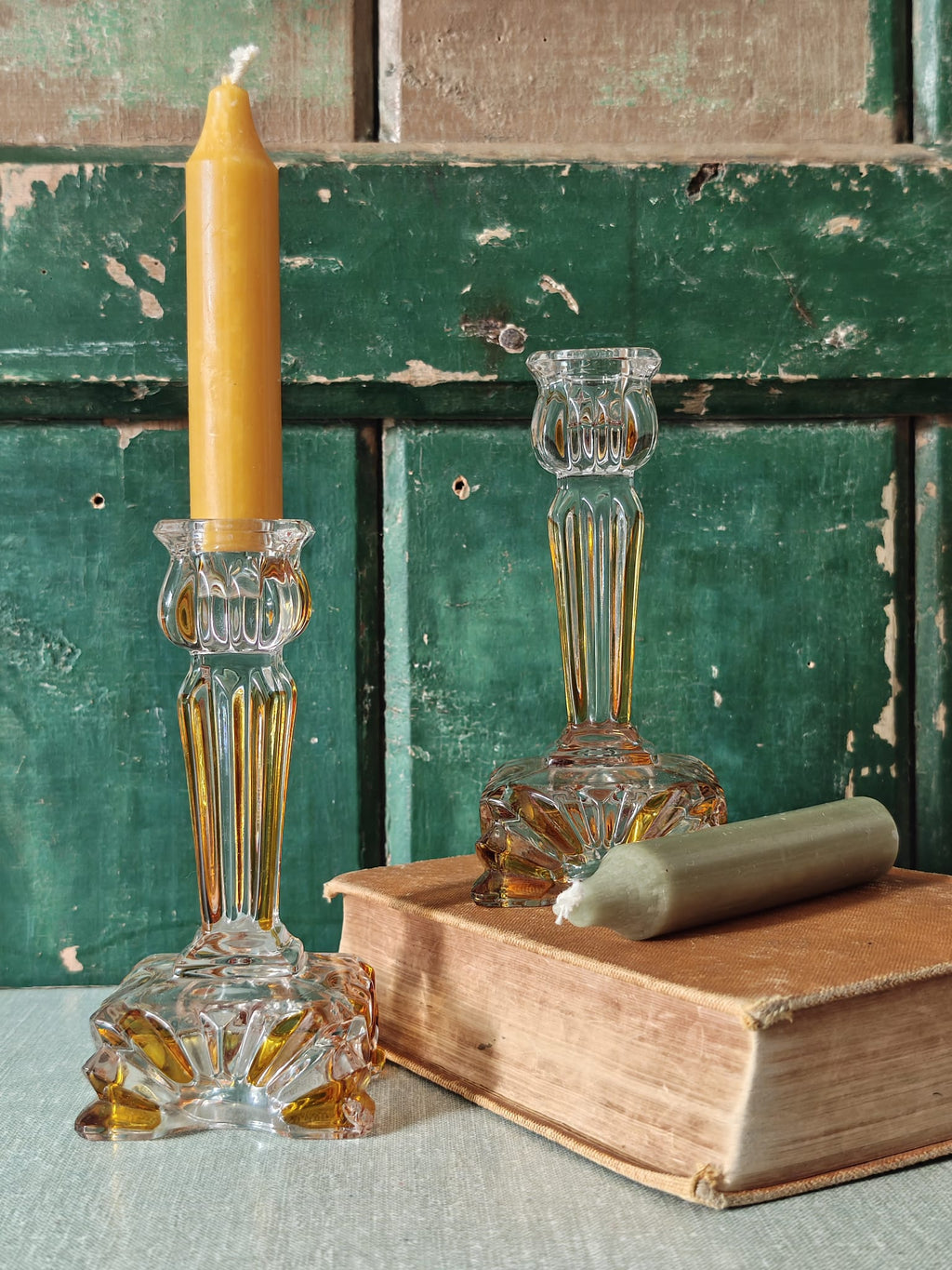 Two clear glass candlestick holders with fluted bases and stems.