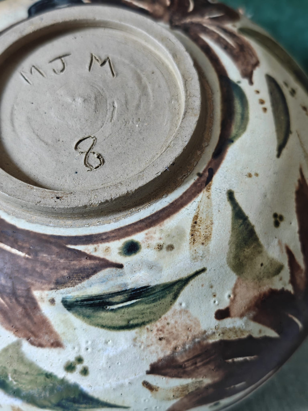 Close-up of the bottom of a handmade ceramic bowl, showing the unglazed clay base.