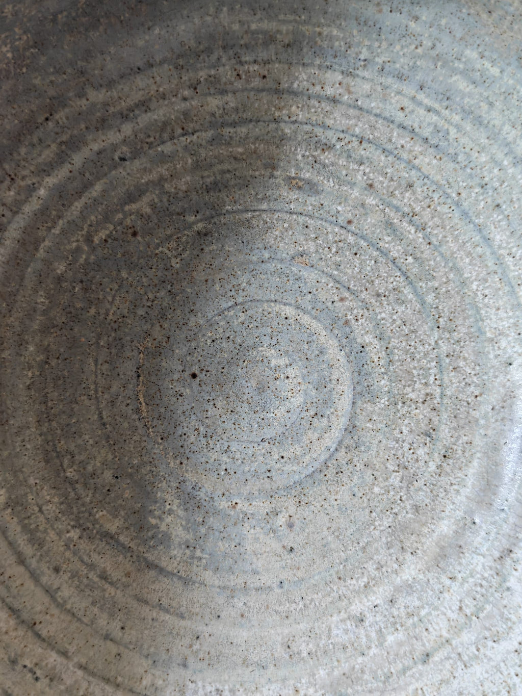 Close-up of the textured interior of a handmade ceramic bowl.