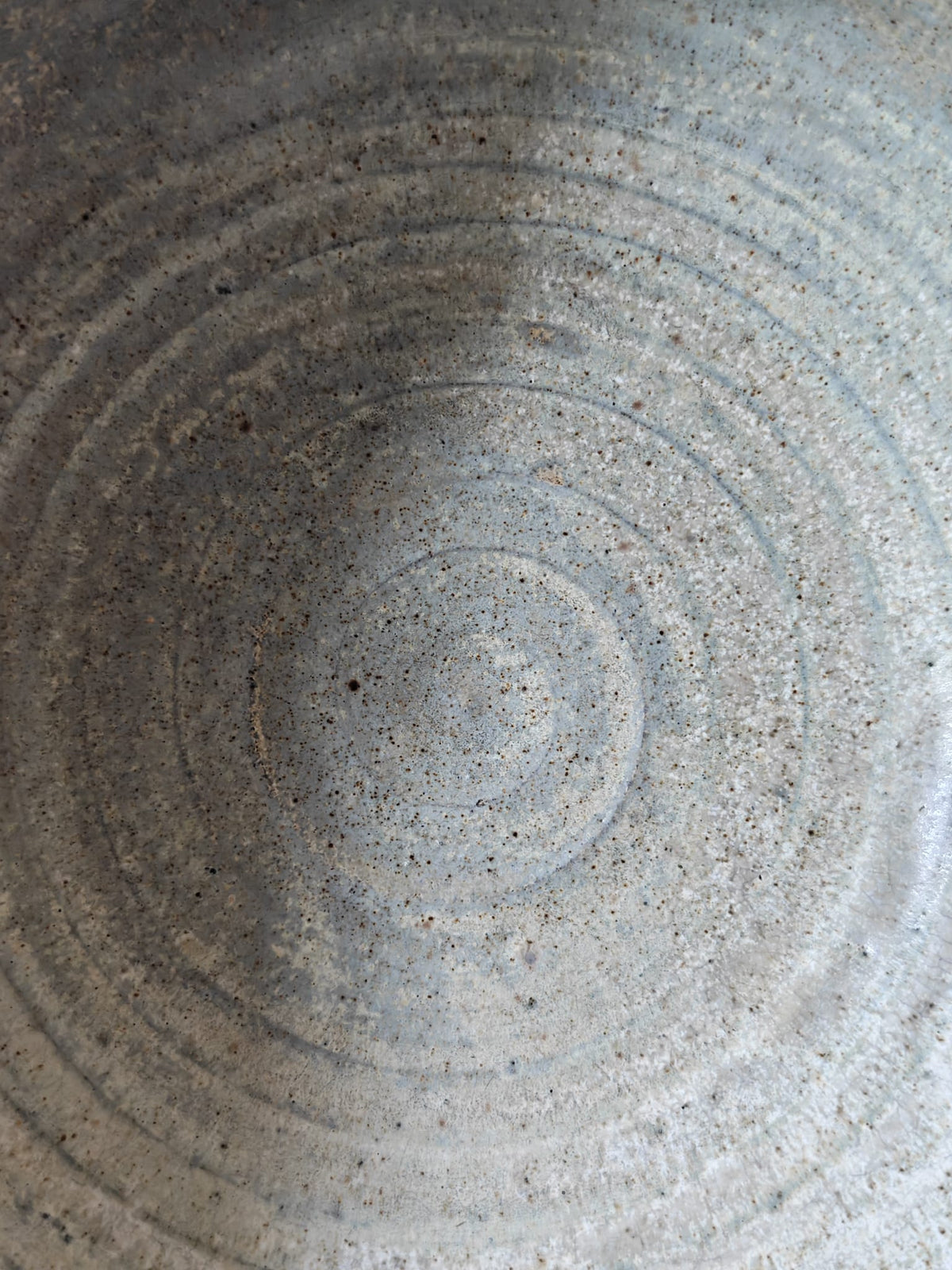 Close-up of the textured interior of a handmade ceramic bowl.