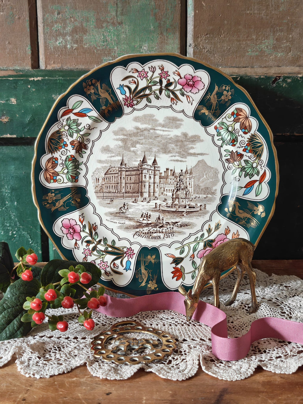 A decorative Christmas plate with a palace illustration and floral border.