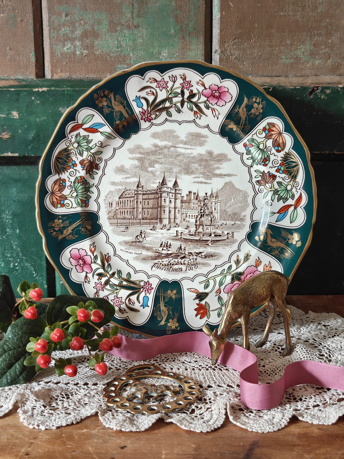 A decorative Christmas plate with a palace illustration and floral border.