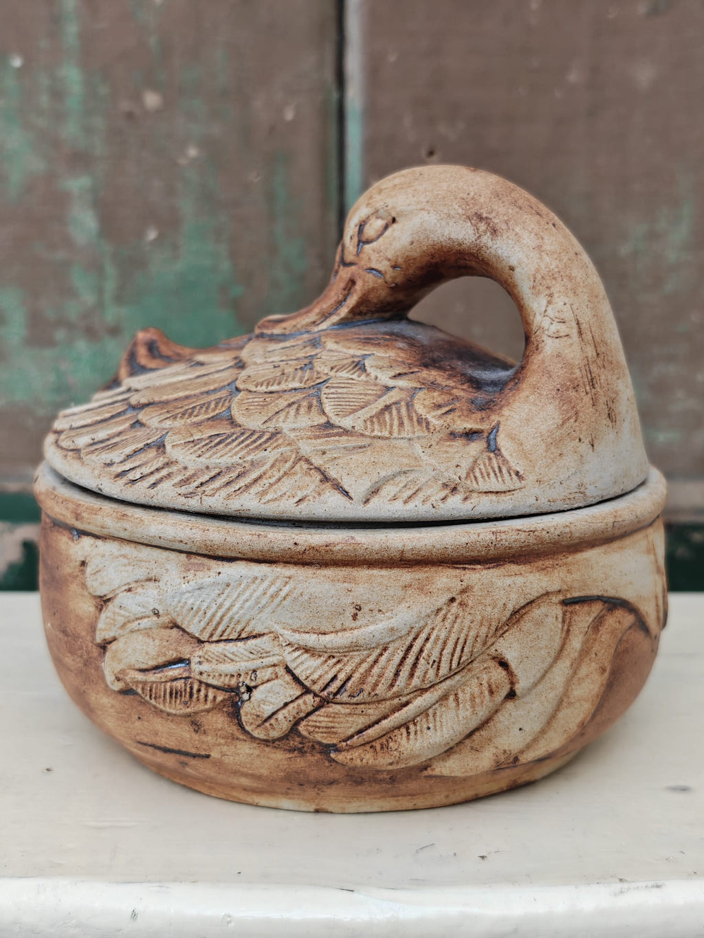 A small handmade ceramic lidded dish shaped like a duck.
