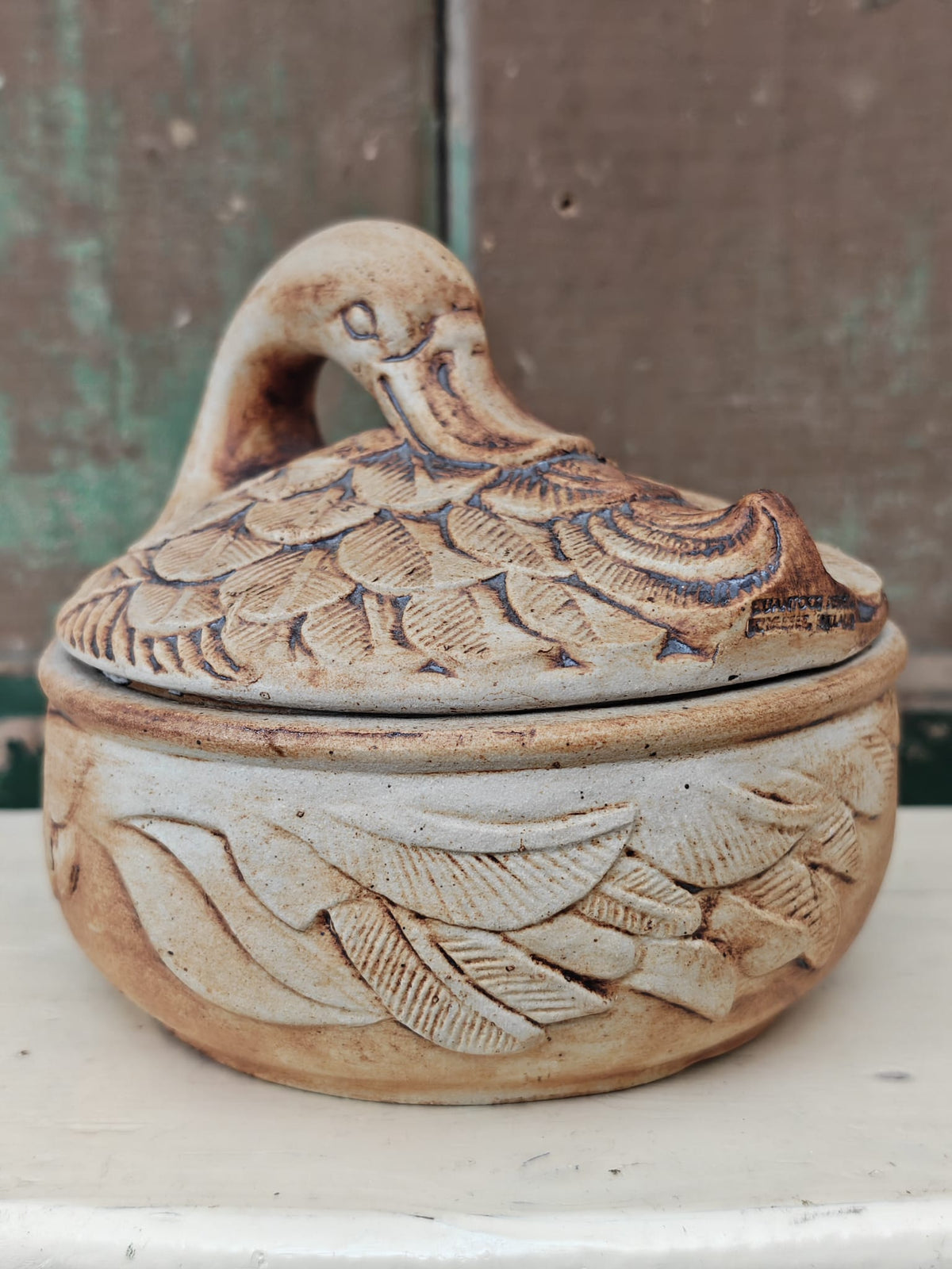 A small handcrafted ceramic lidded dish shaped like a duck.