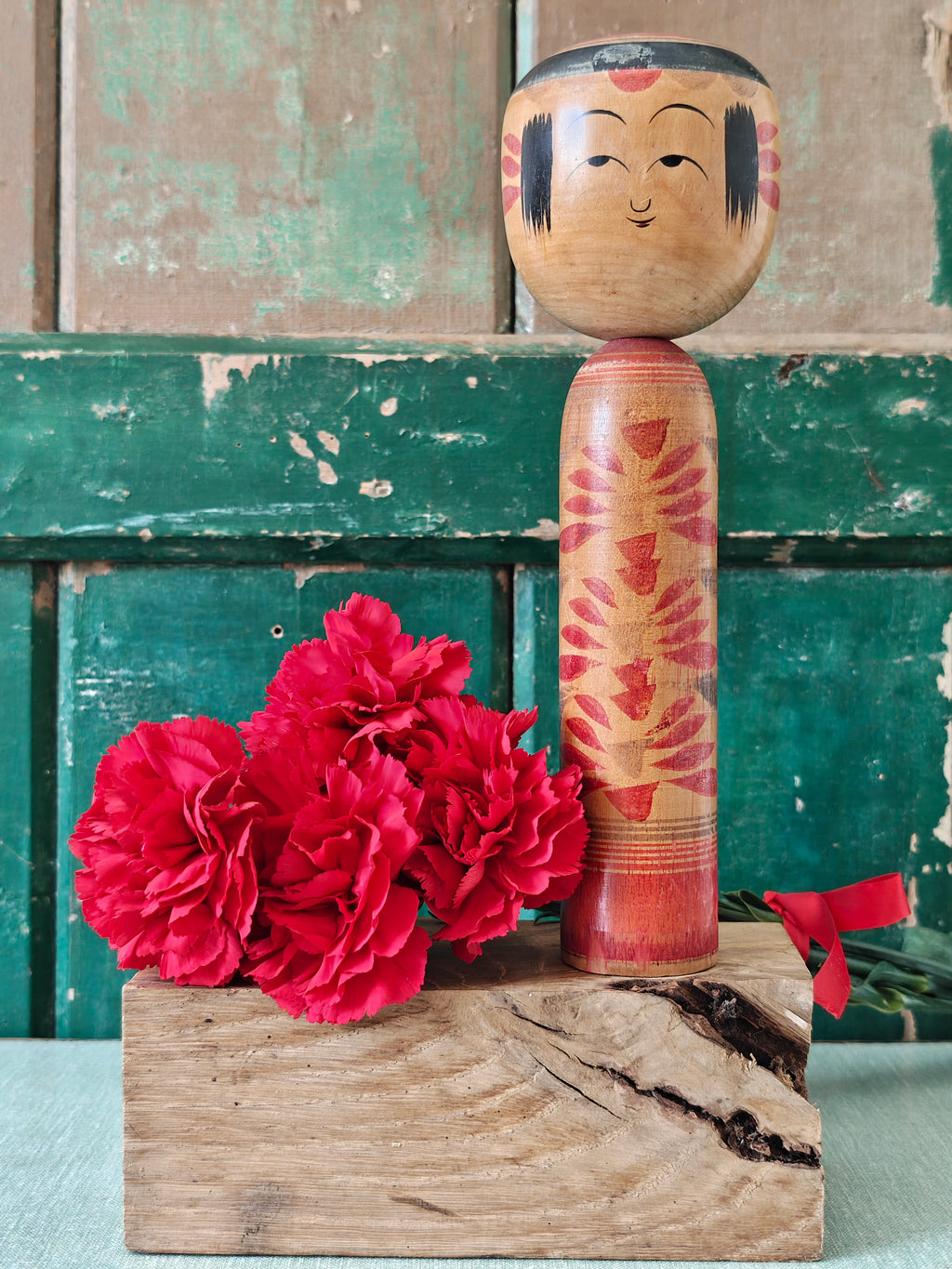 Wooden kokeshi doll with black and red painted decoration