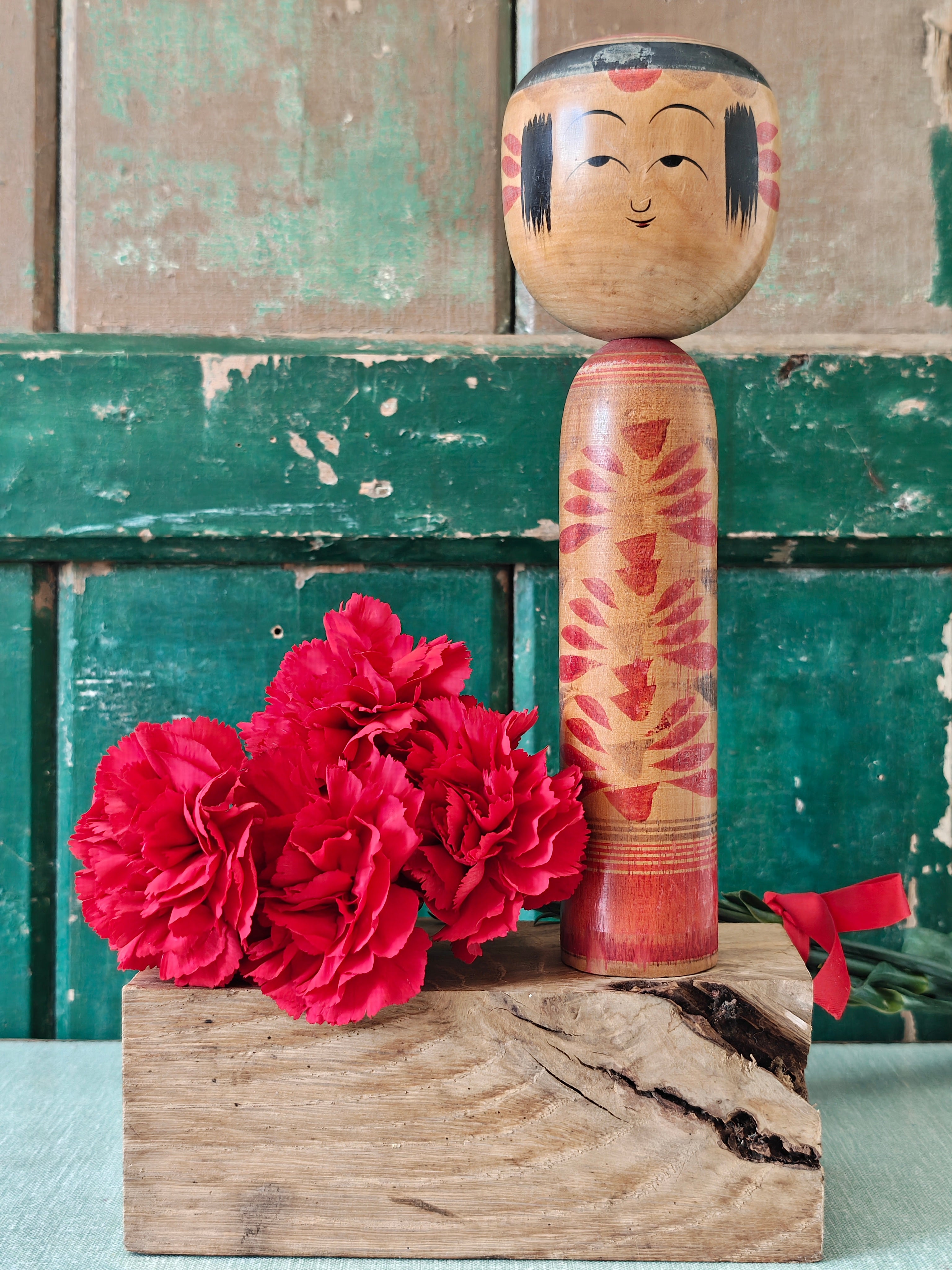 Wooden kokeshi doll with black and red painted decoration