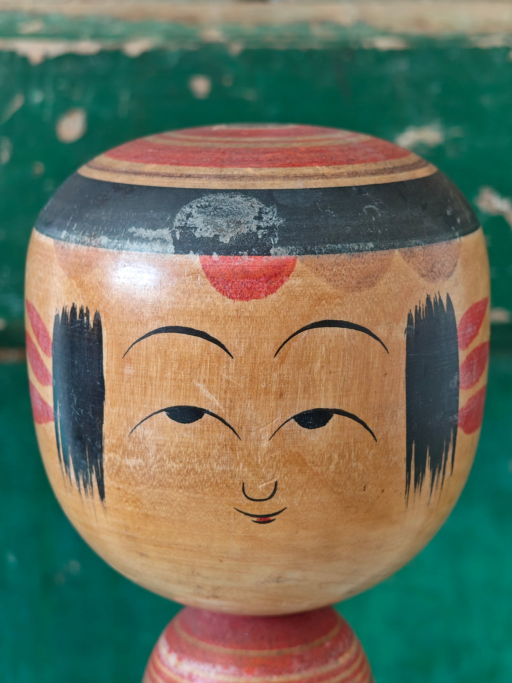 Wooden kokeshi doll head with hand painted face design