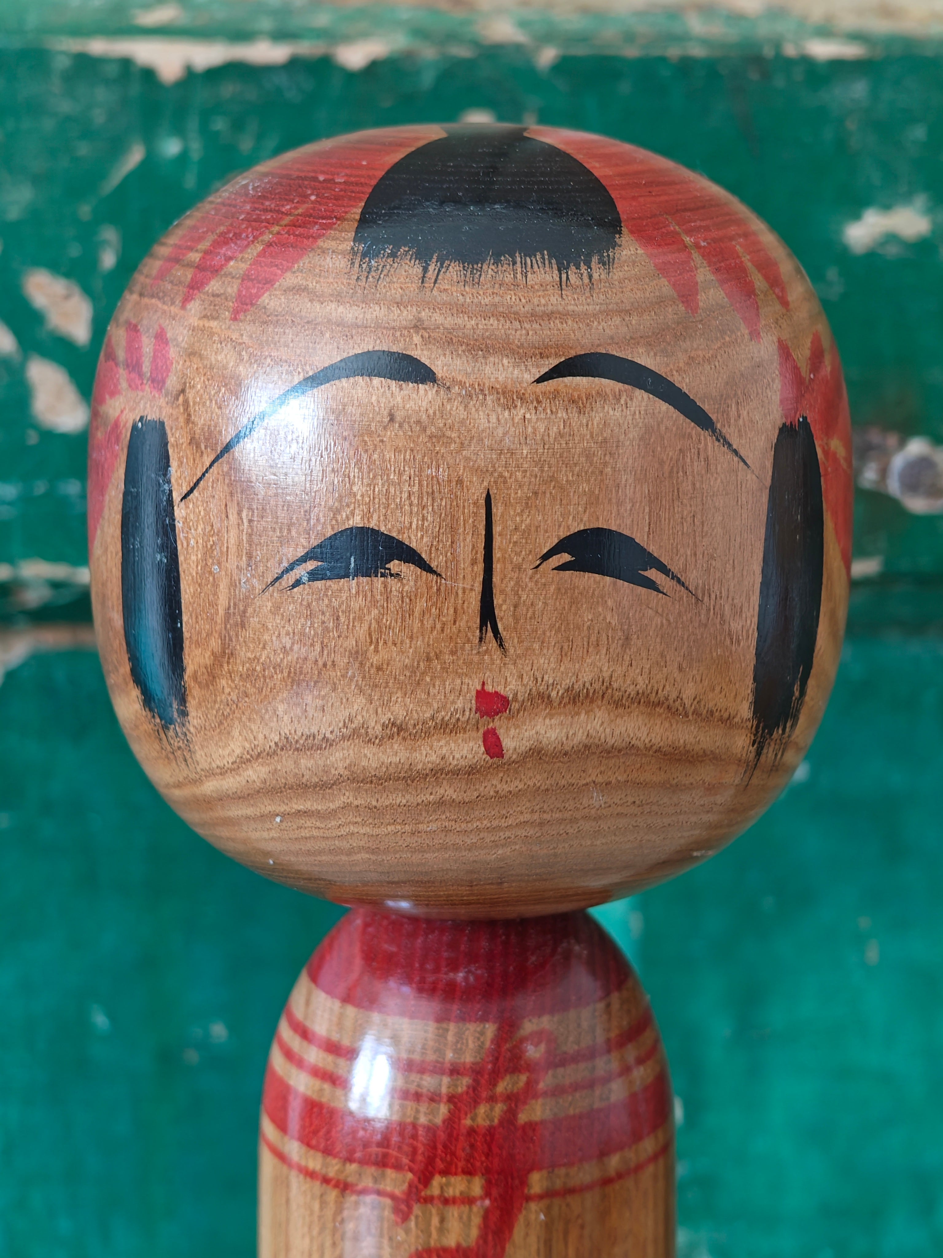 Head of a wooden kokeshi doll with a face painted 