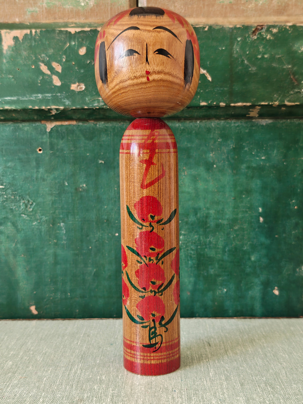 Wooden kokeshi doll with traditional floral design 