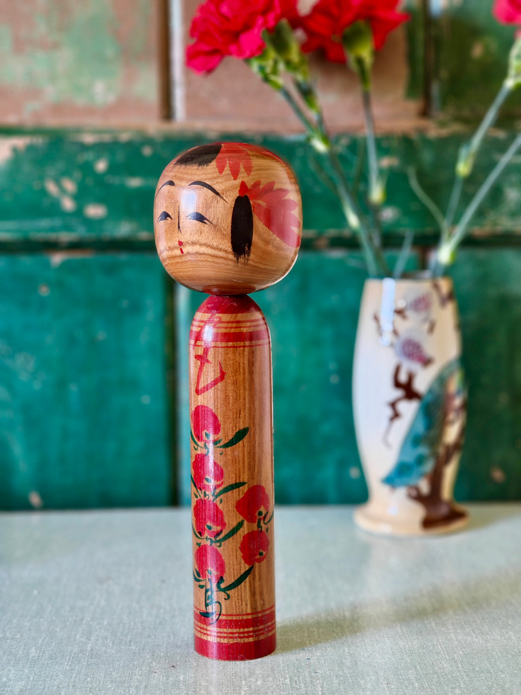 Wooden kokeshi doll with floral design