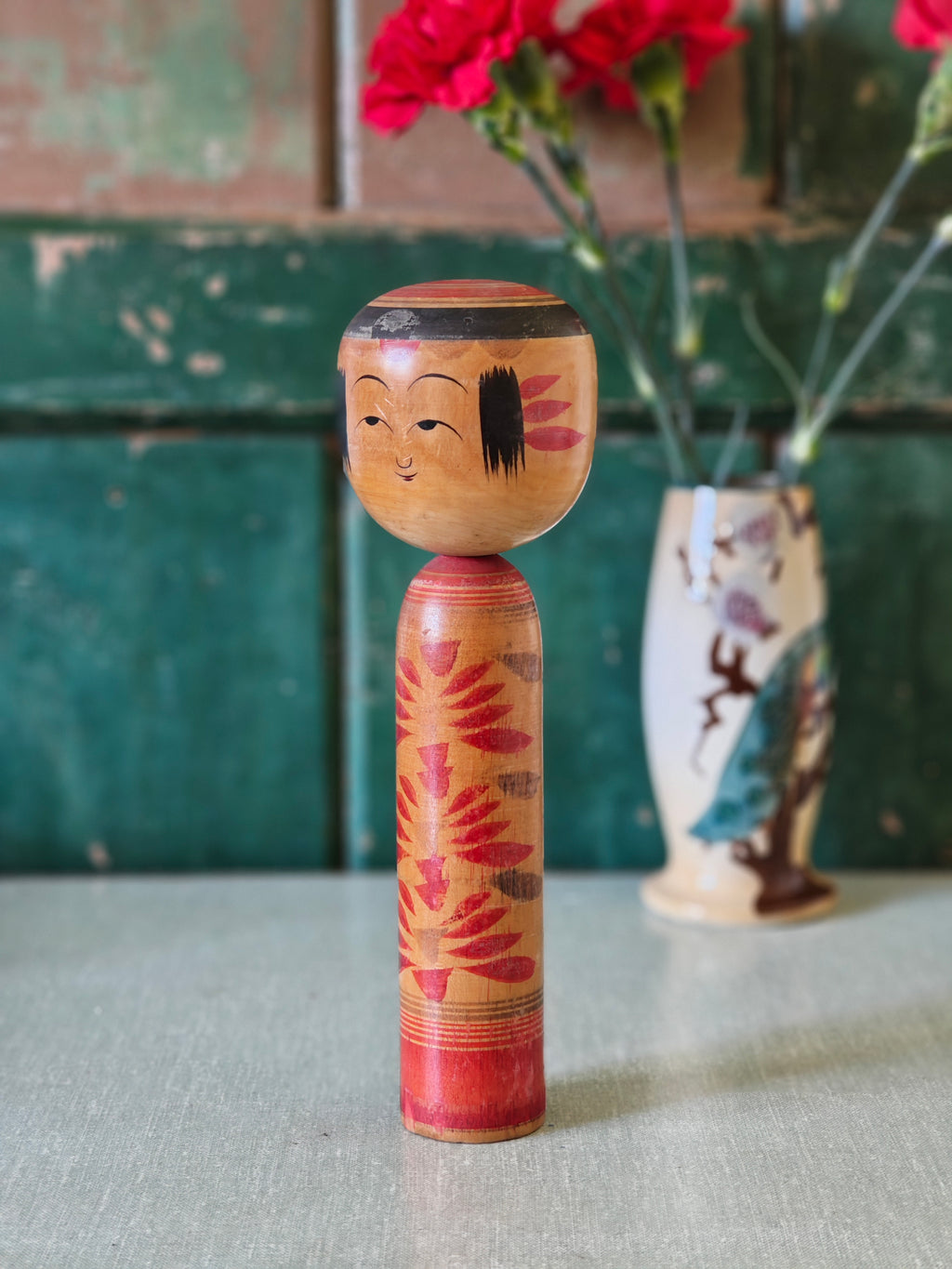 Traditional Japanese kokeshi doll with floral patterns 