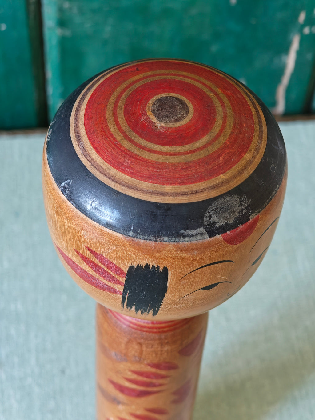 Close-up of head of wooden kokeshi doll showing top of head