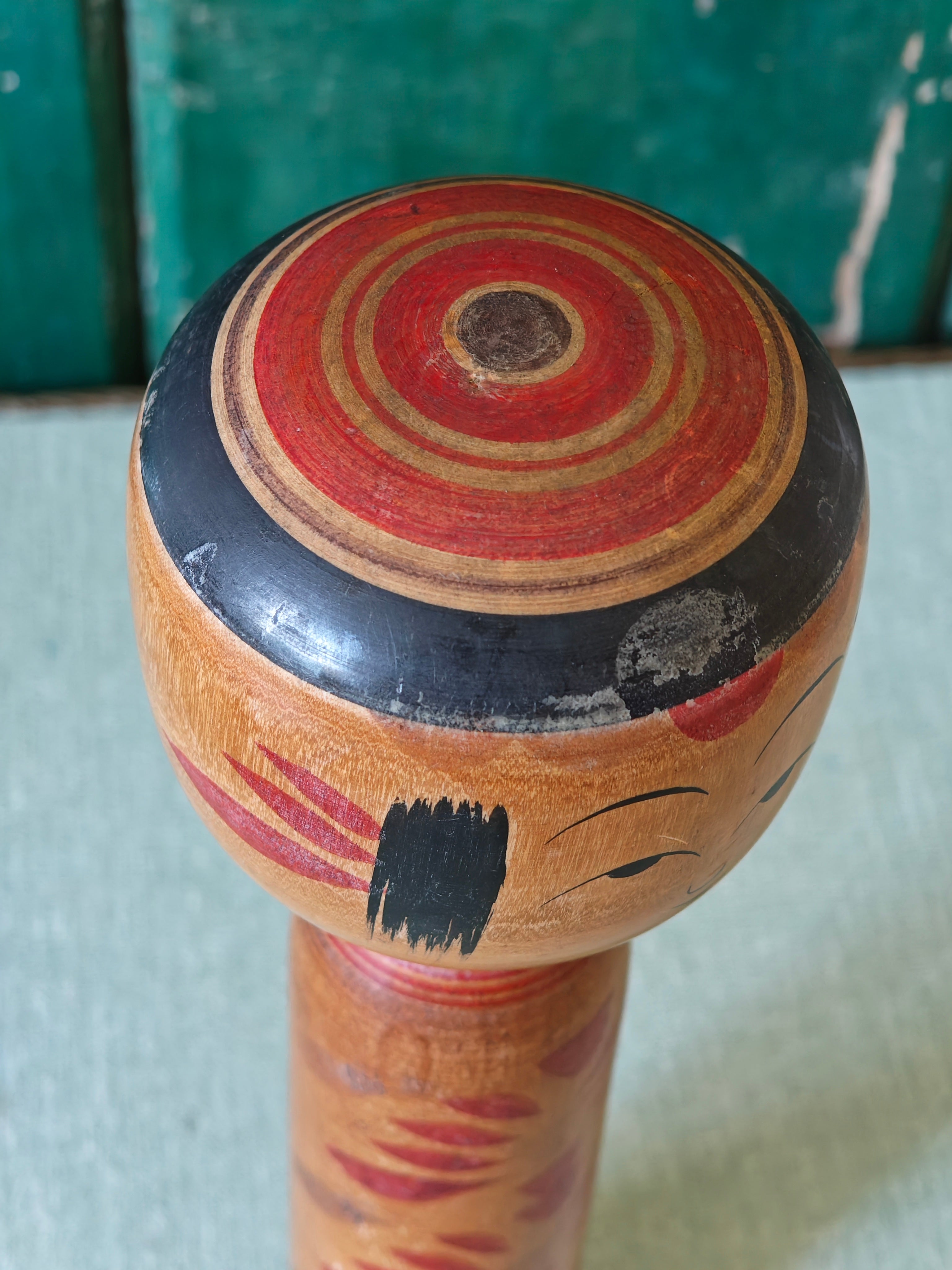 Close-up of head of wooden kokeshi doll showing top of head