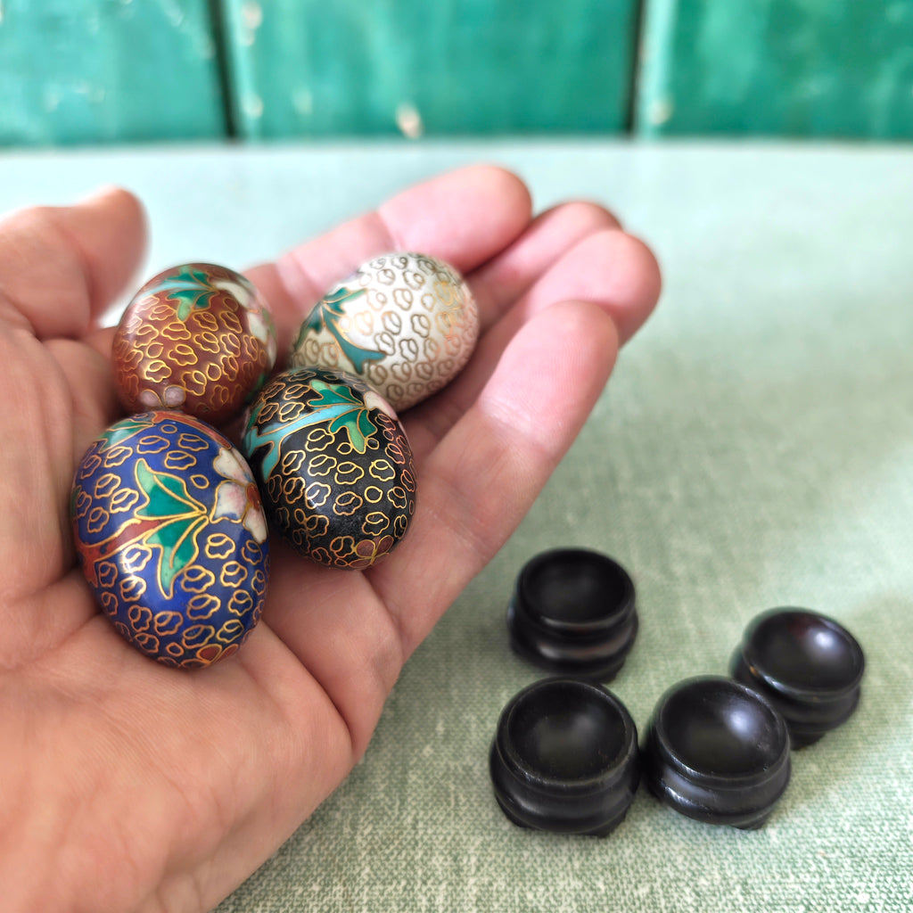 Hand holding decorative Chinese cloisonne eggs