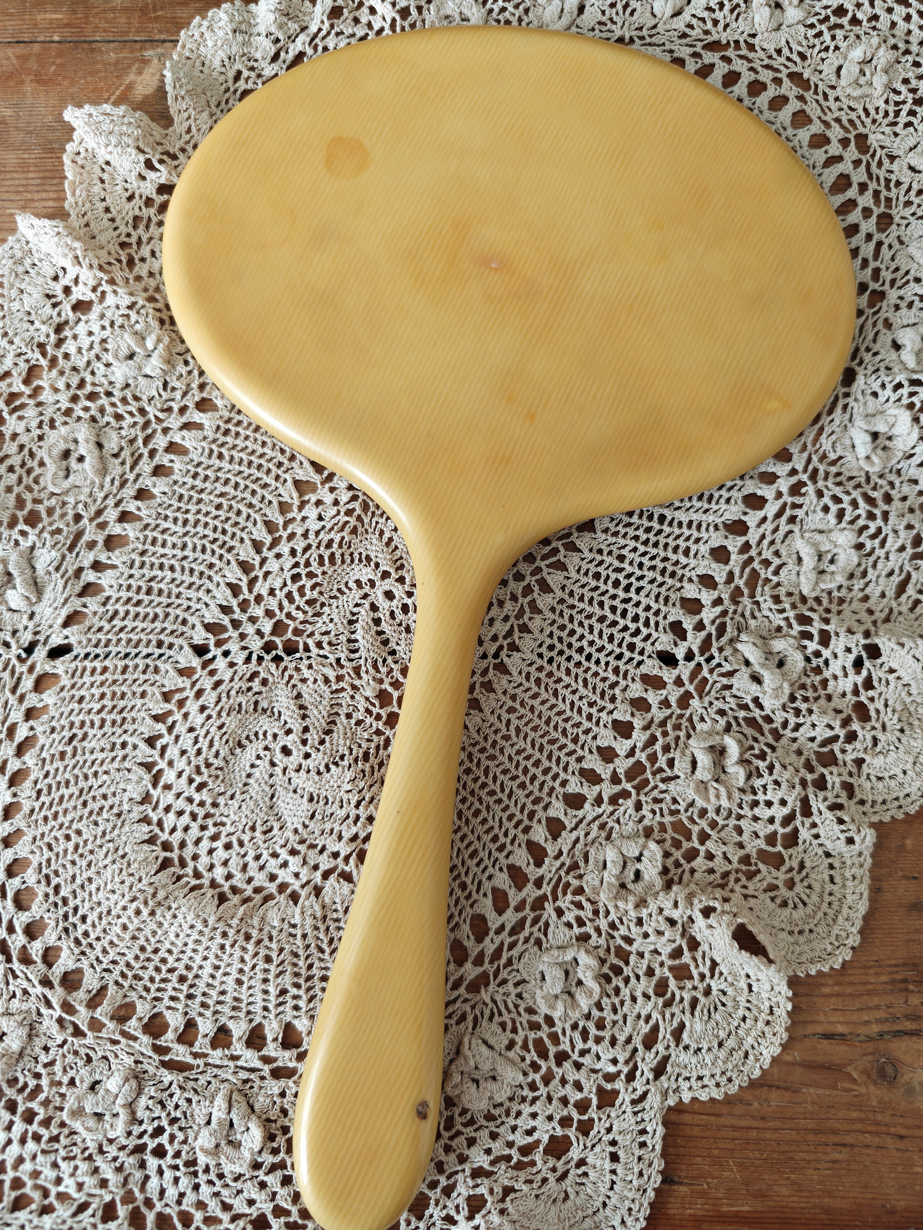 Back view of a vintage ivory coloured oval hand mirror