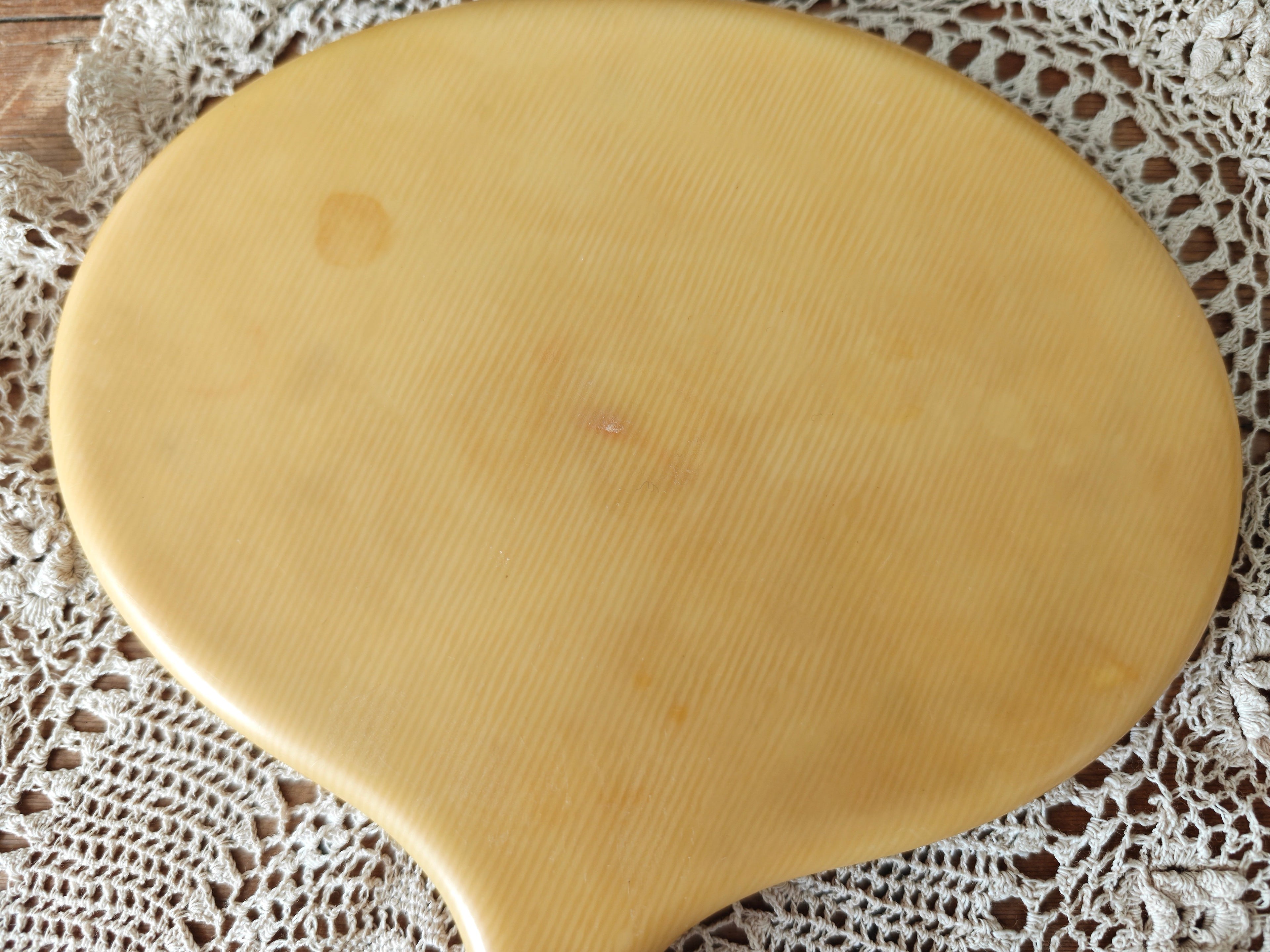 Close-up of the back of a vintage ivory coloured oval hand mirror