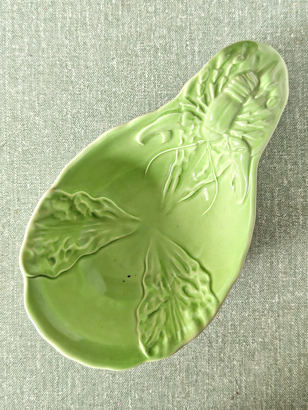 Green ceramic dish showing lobster and leaf pattern