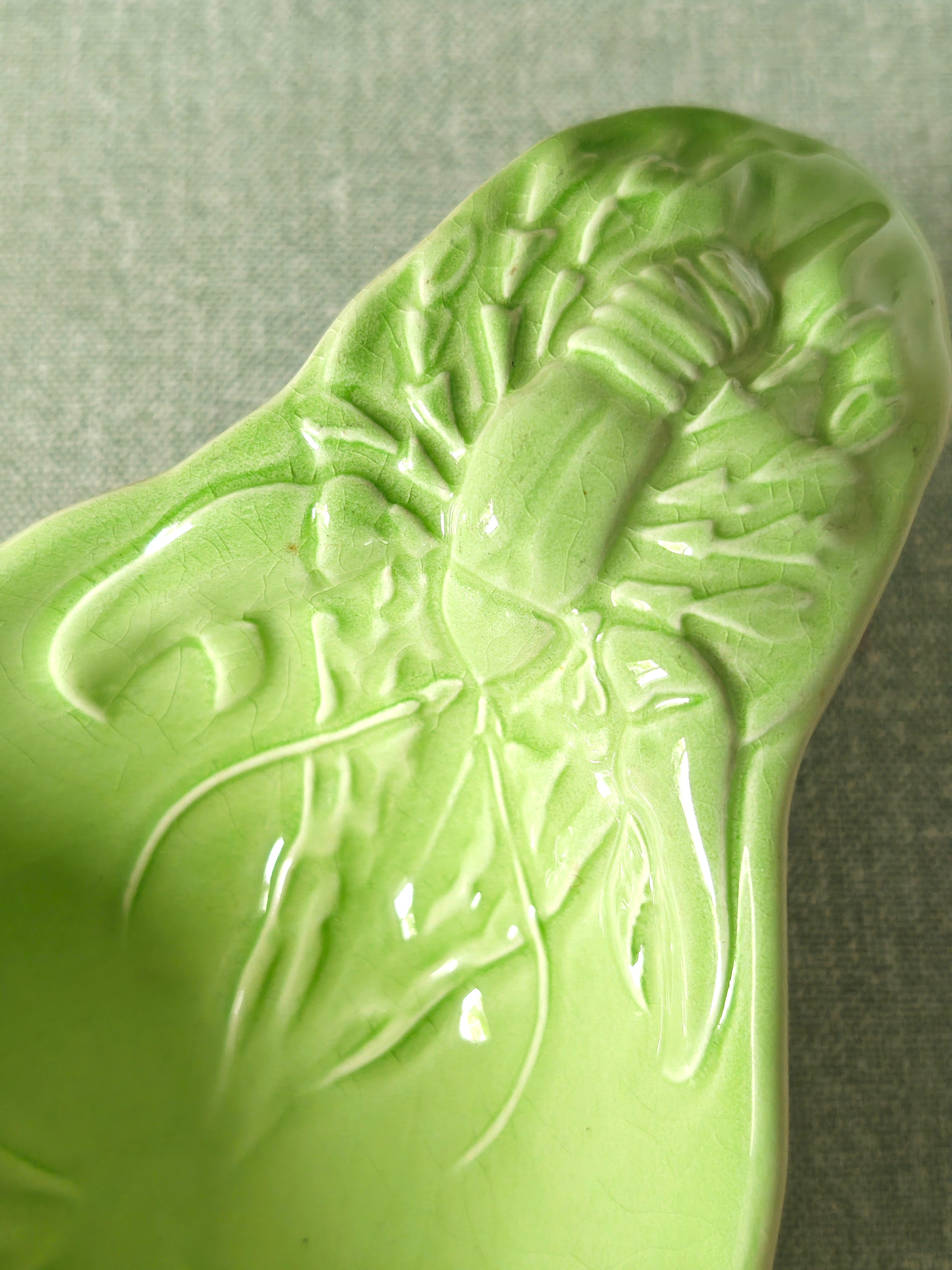 Close-up of lobster design on a green ceramic dish