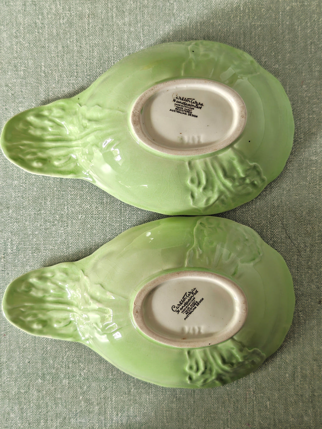 Two green ceramic dishes showing makers mark