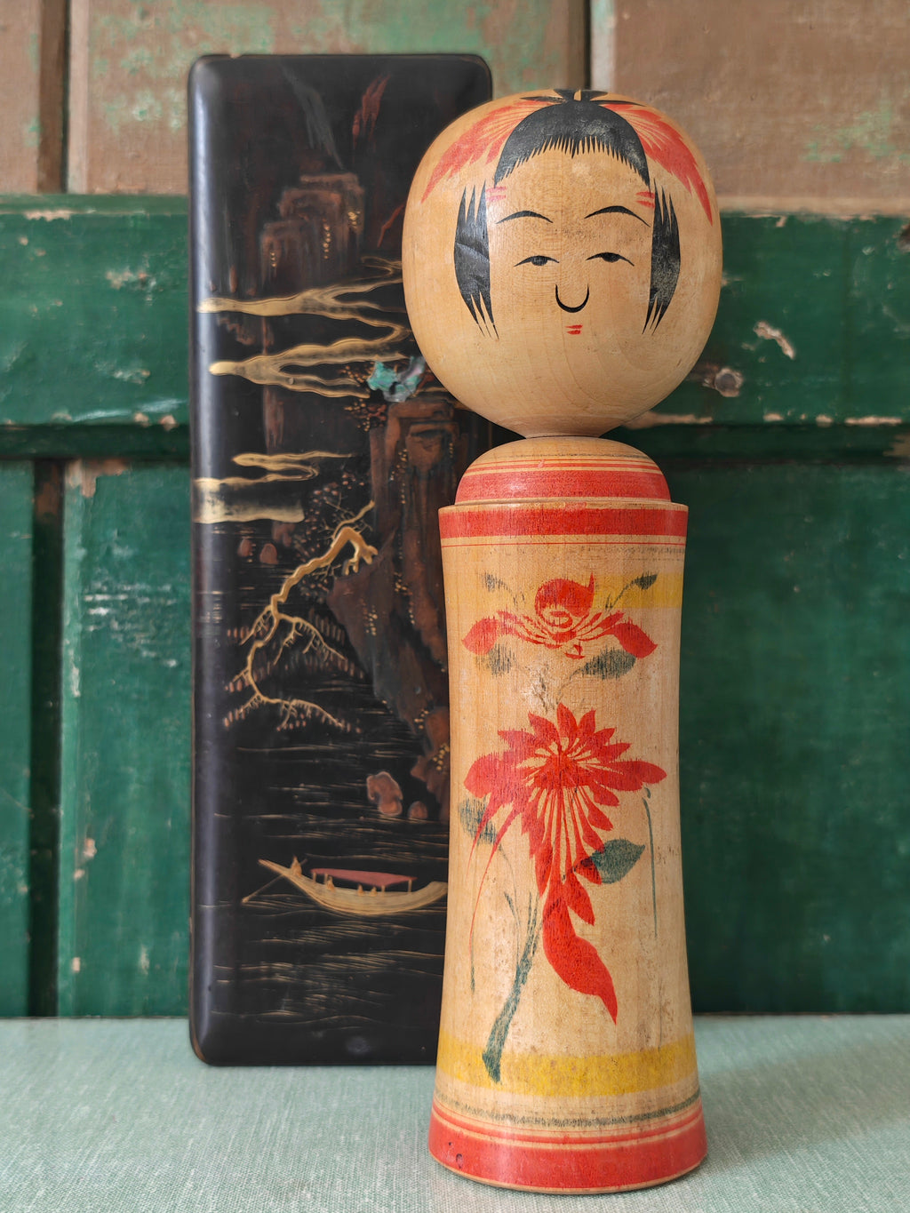 Vintage wooden kokeshi doll with floral design 