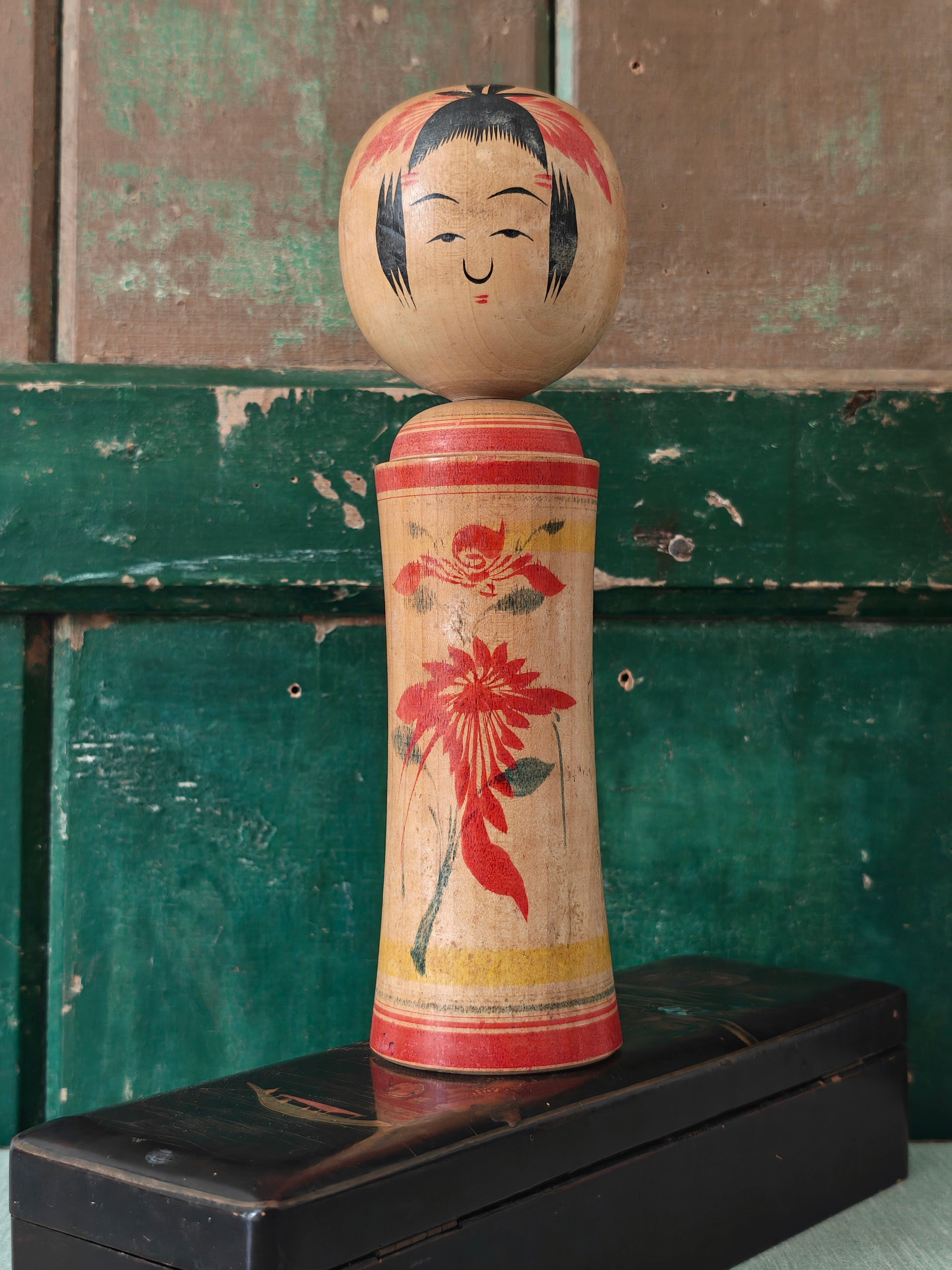 Vintage wooden kokeshi doll with floral design 