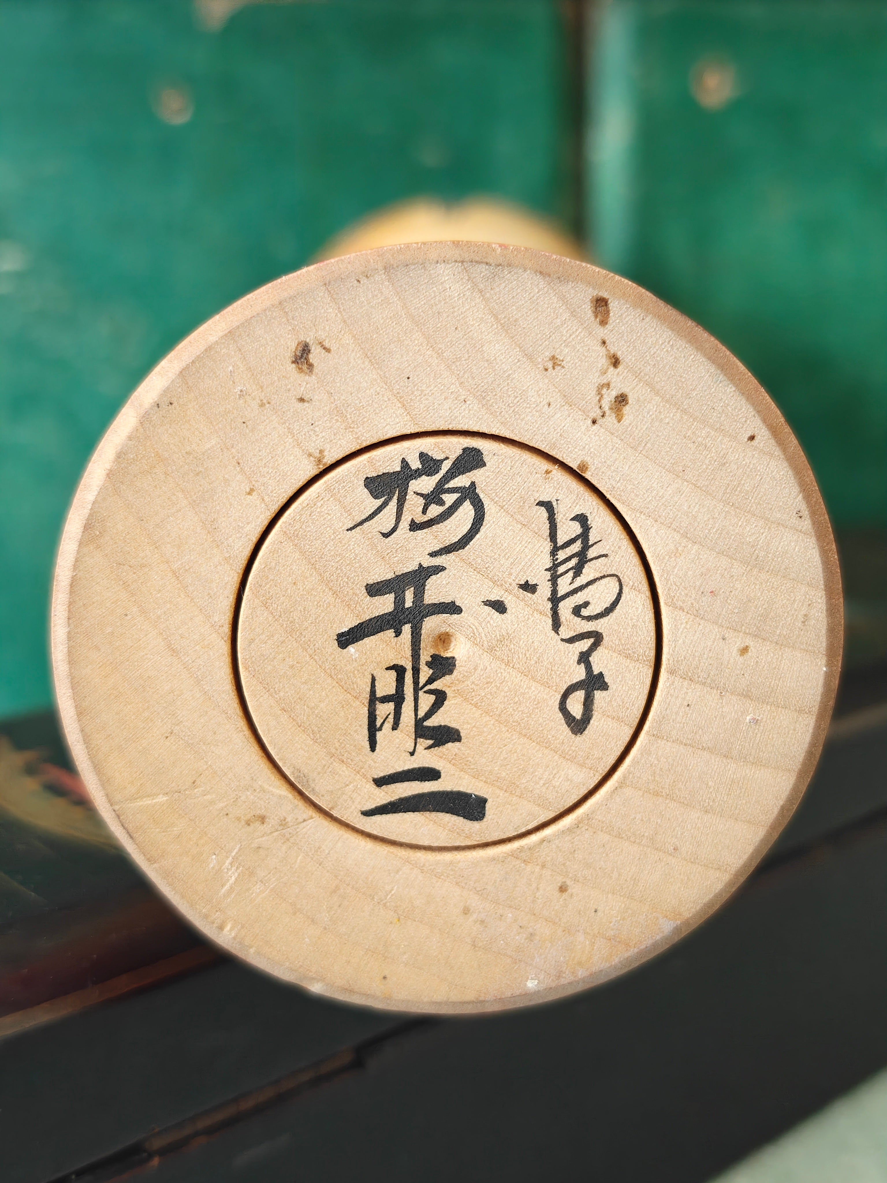 Japanese signature on the base of a Kokeshi doll