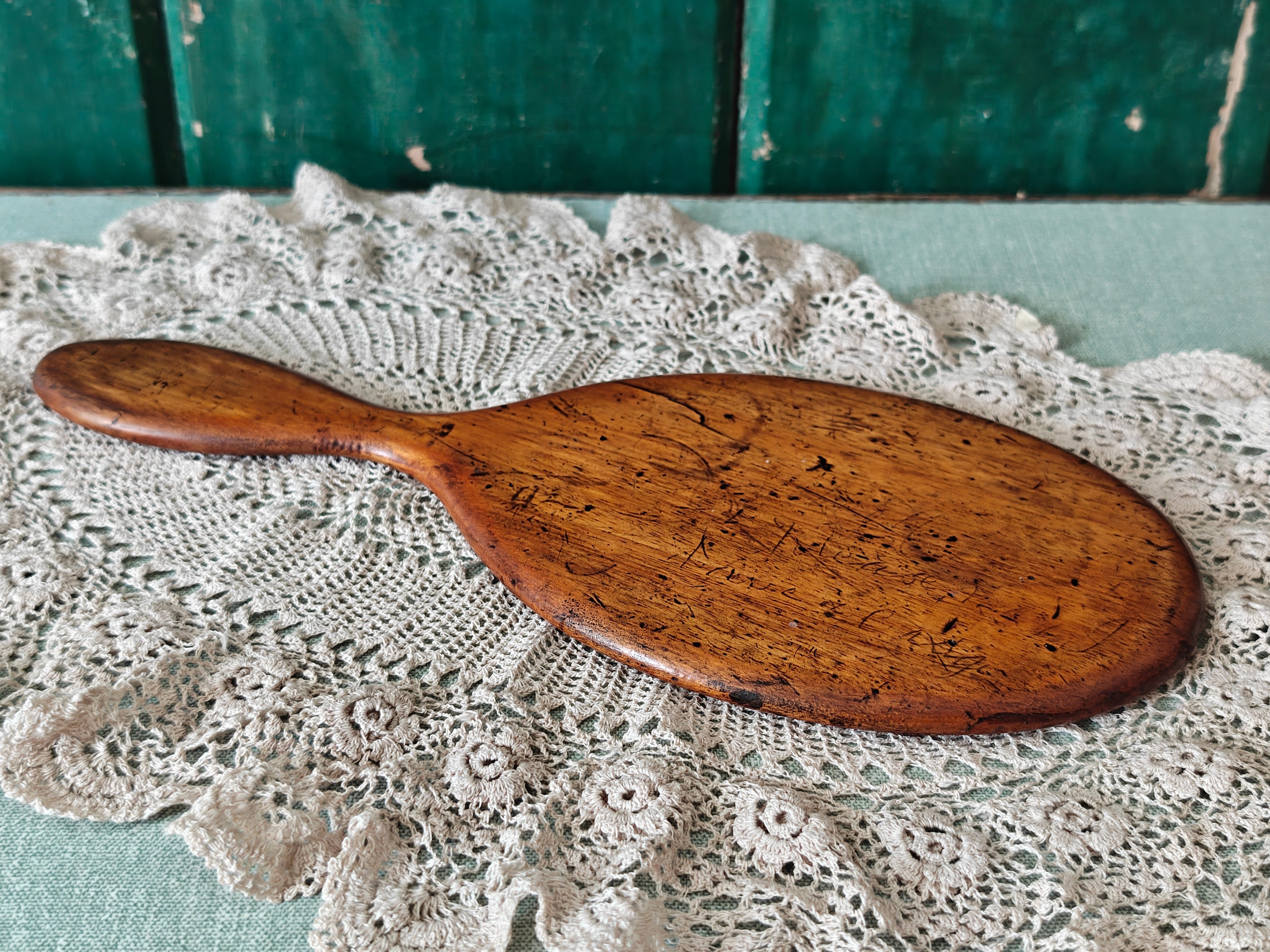 Back of an antique wooden oval hand mirror 