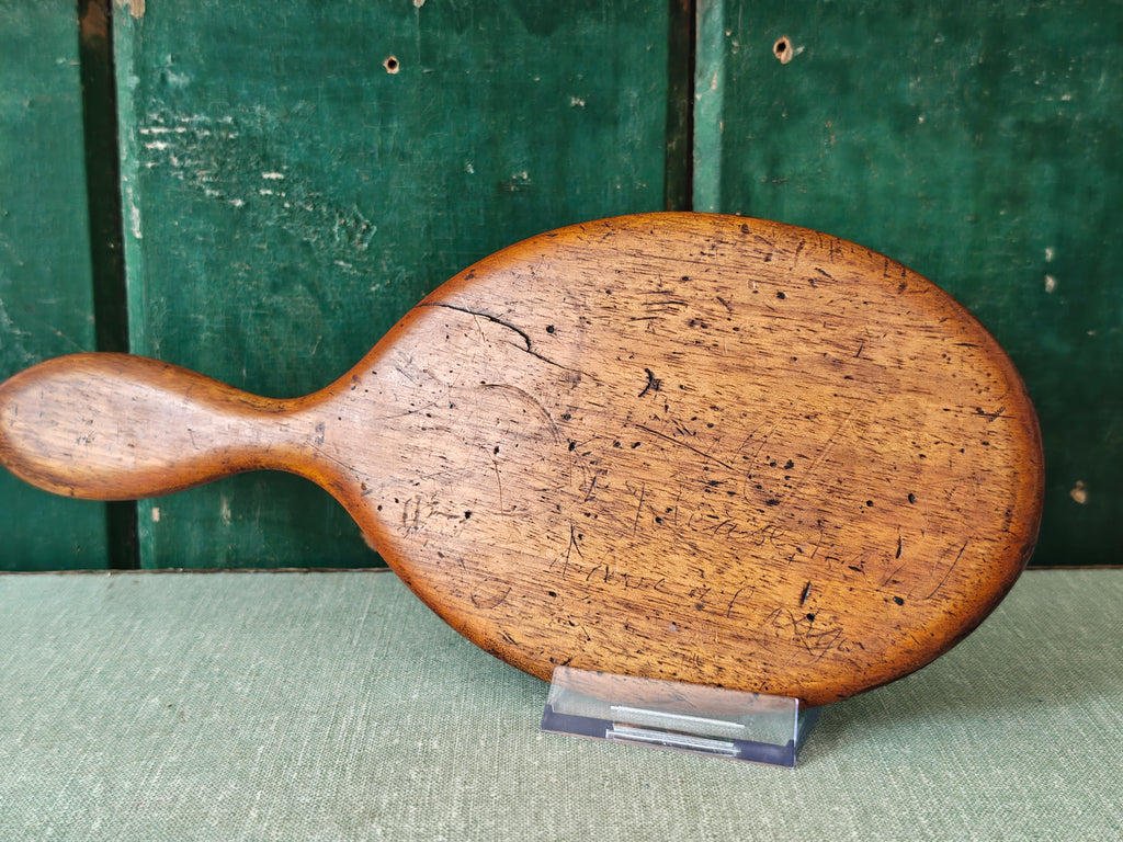 Back of an antique wooden oval hand mirror 