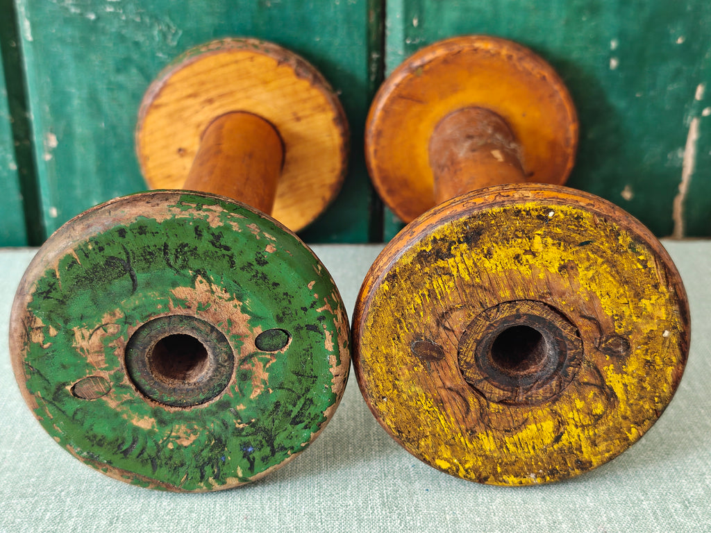 Two vintage wooden spools with traces of paint