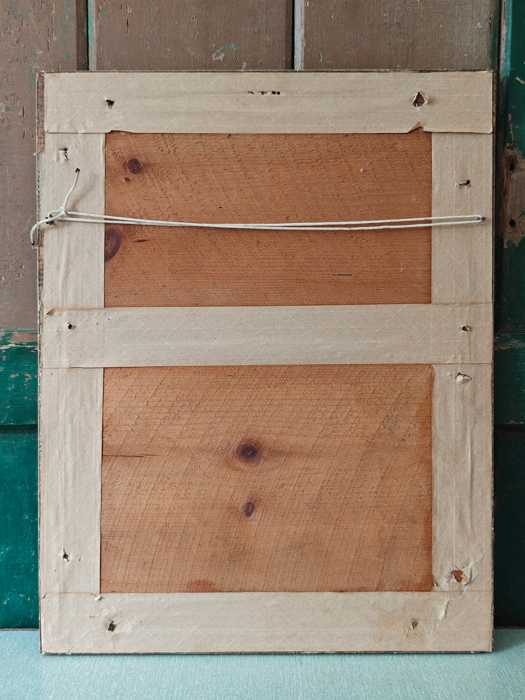 Back view of a wooden picture frame with visible nails and wood grain.