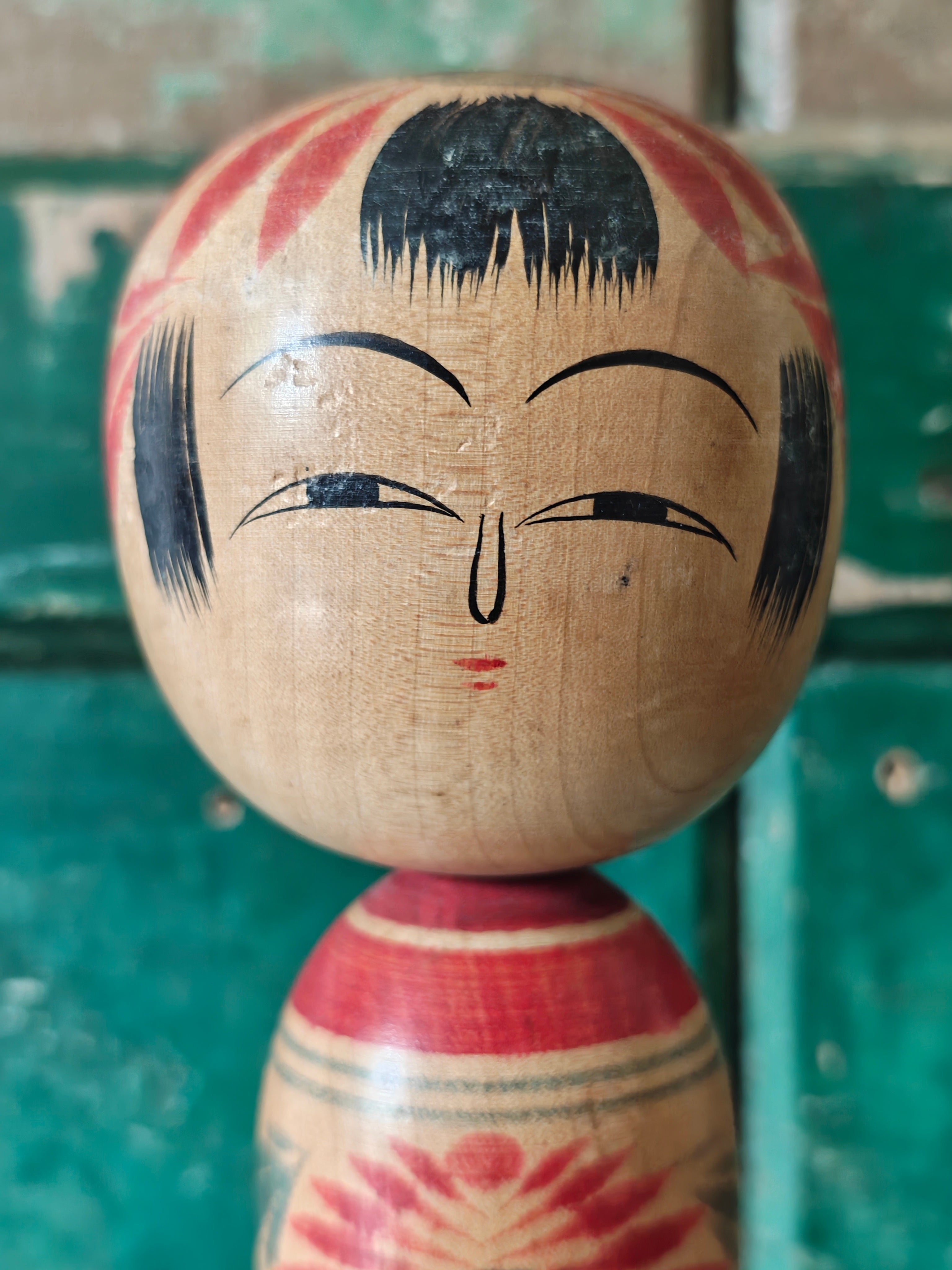 Close up of the face of a vintage wooden Kokeshi doll