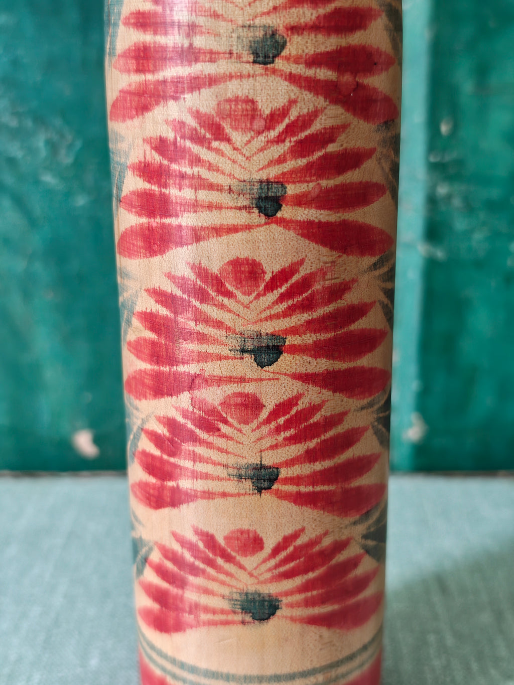 Close up showing decoration on the body of a vintage wooden Kokeshi doll
