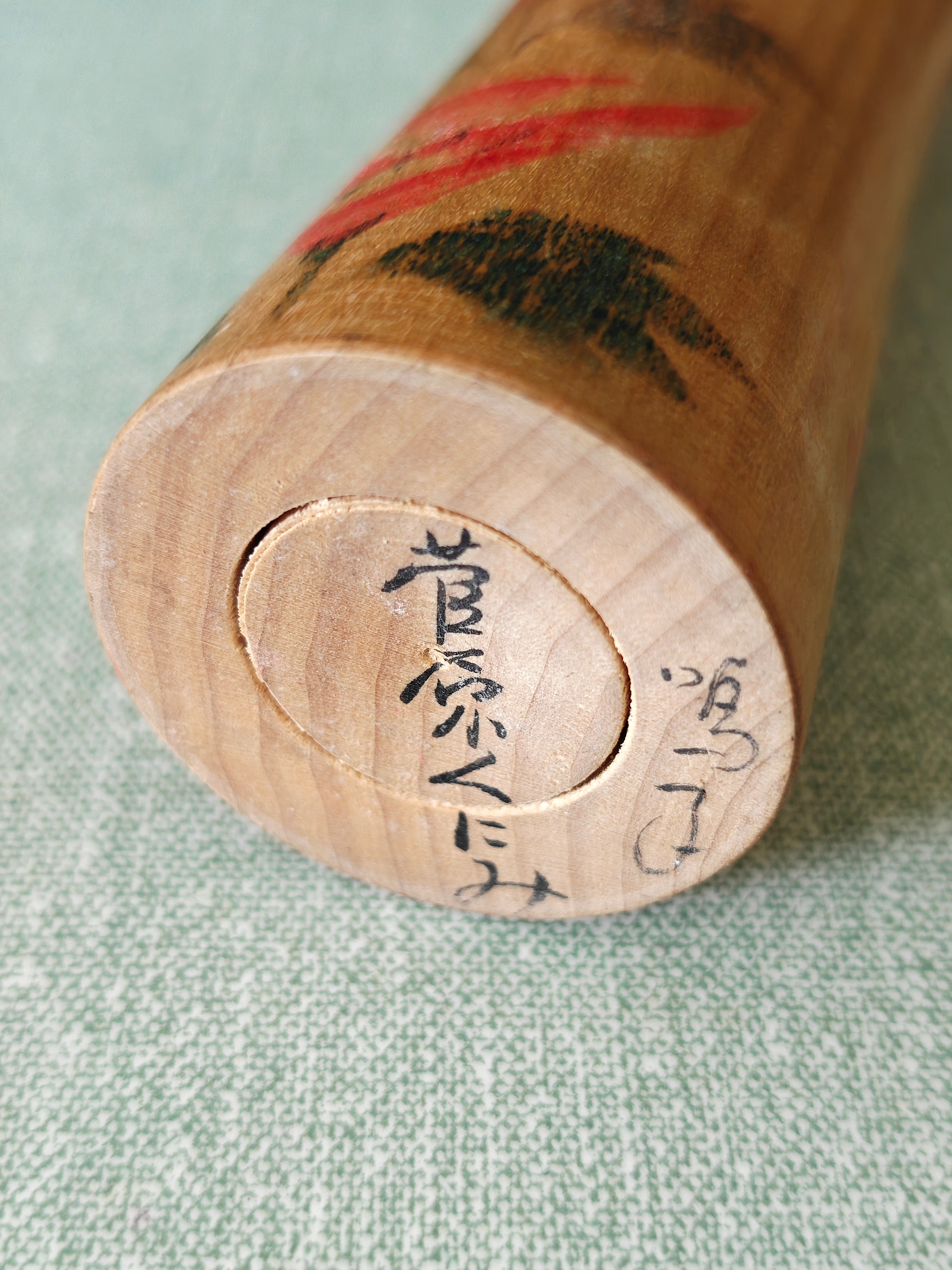 Artist's signature on the base of a traditional wooden kokeshi doll