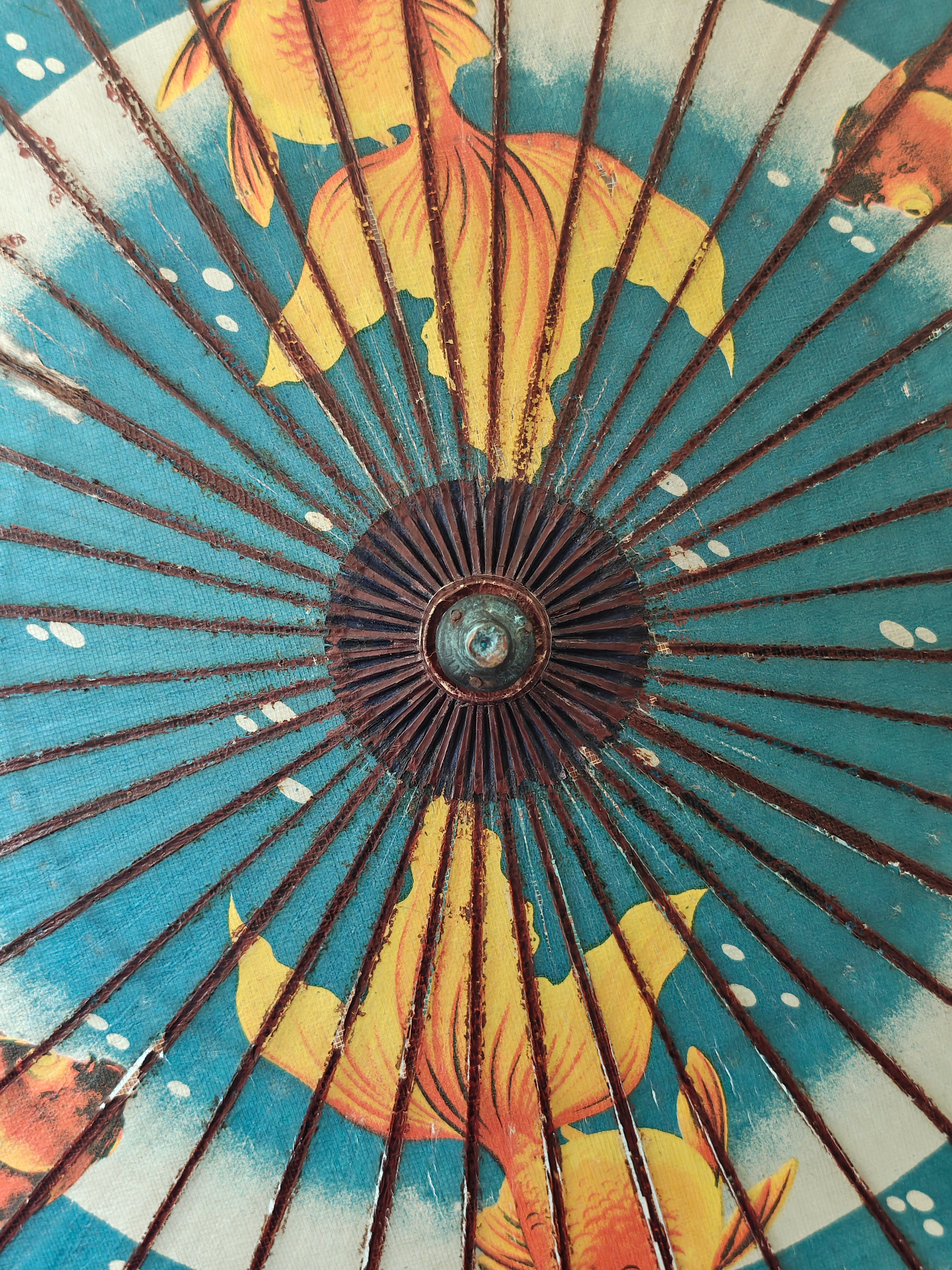 Close-up of a decorative wood and paper Chinese parasol with gold fish pattern