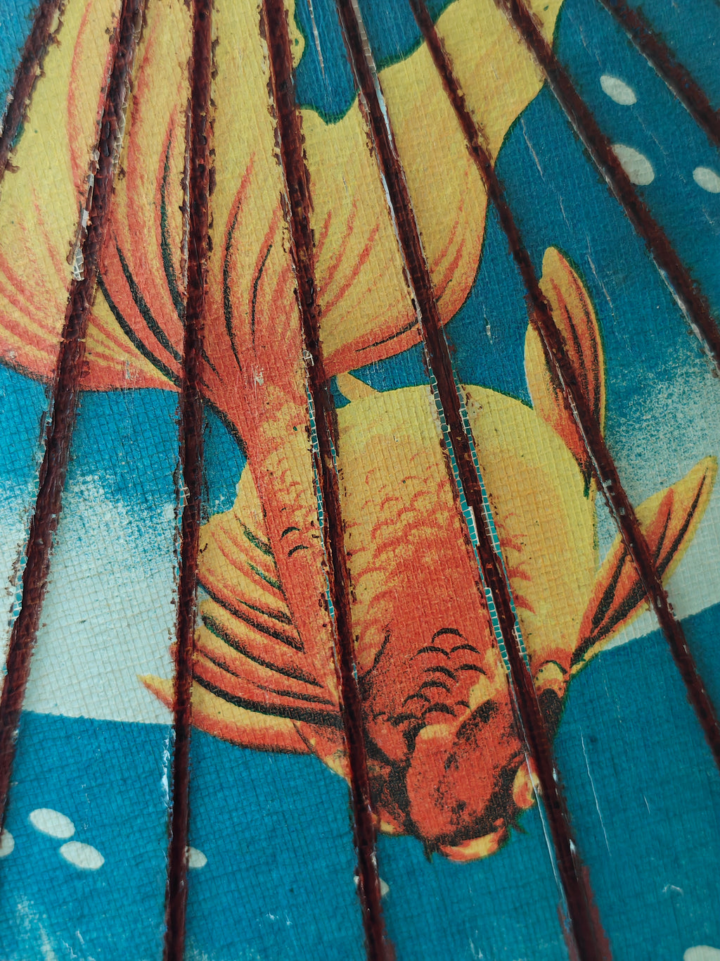 Close-up of a decorative wood and paper Chinese parasol with gold fish pattern